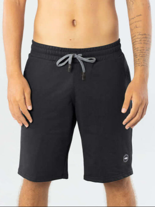 Modelo masculino usando Bermuda Moletom Basic preta da Greenish, ideal para conforto e estilo em dias de meia estação.