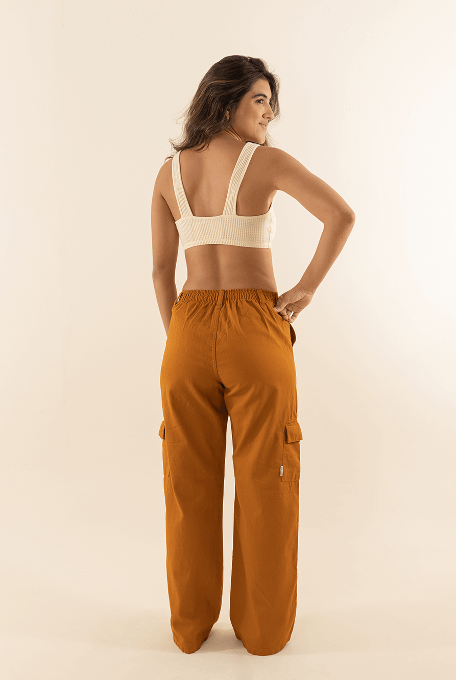 Modelo usando calça cargo sarja Gio caramel com caimento reto e cintura alta da marca Greenish.