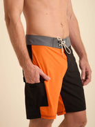 Boardshort Color Blocks da Greenish, em preto e laranja, com cós anatômico e bolso cargo lateral.