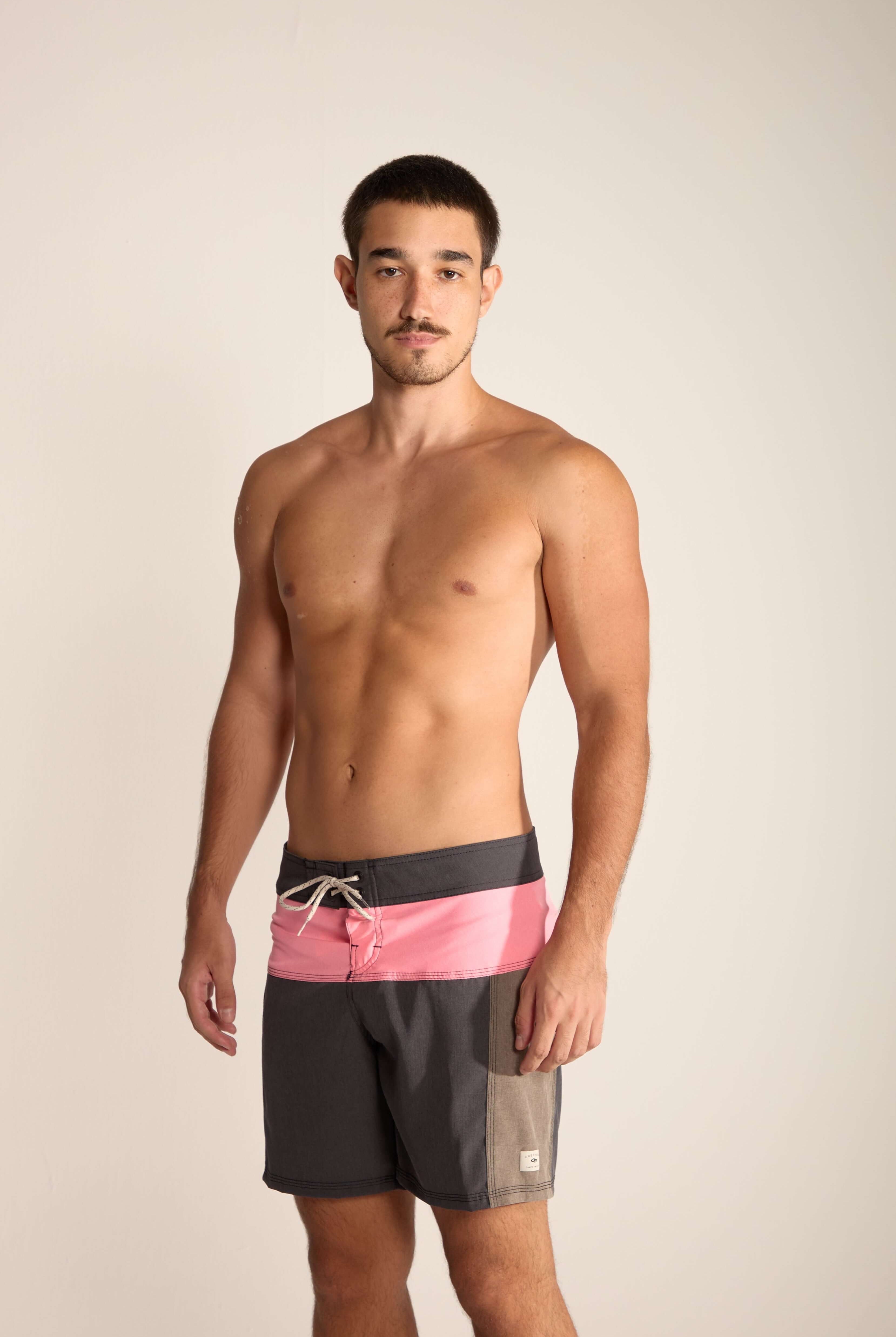 Modelo usando bermuda Boardwalk Backoutdoor da Greenish, com design moderno em tons de cinza e rosa, ideal para atividades aquáticas.