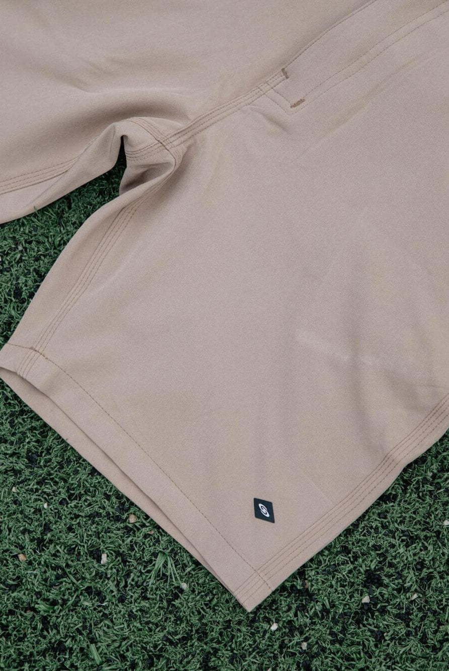 Bermuda Walkshort Classic Caqui da marca Greenish com botão e bolsos traseiros sobre fundo verde.