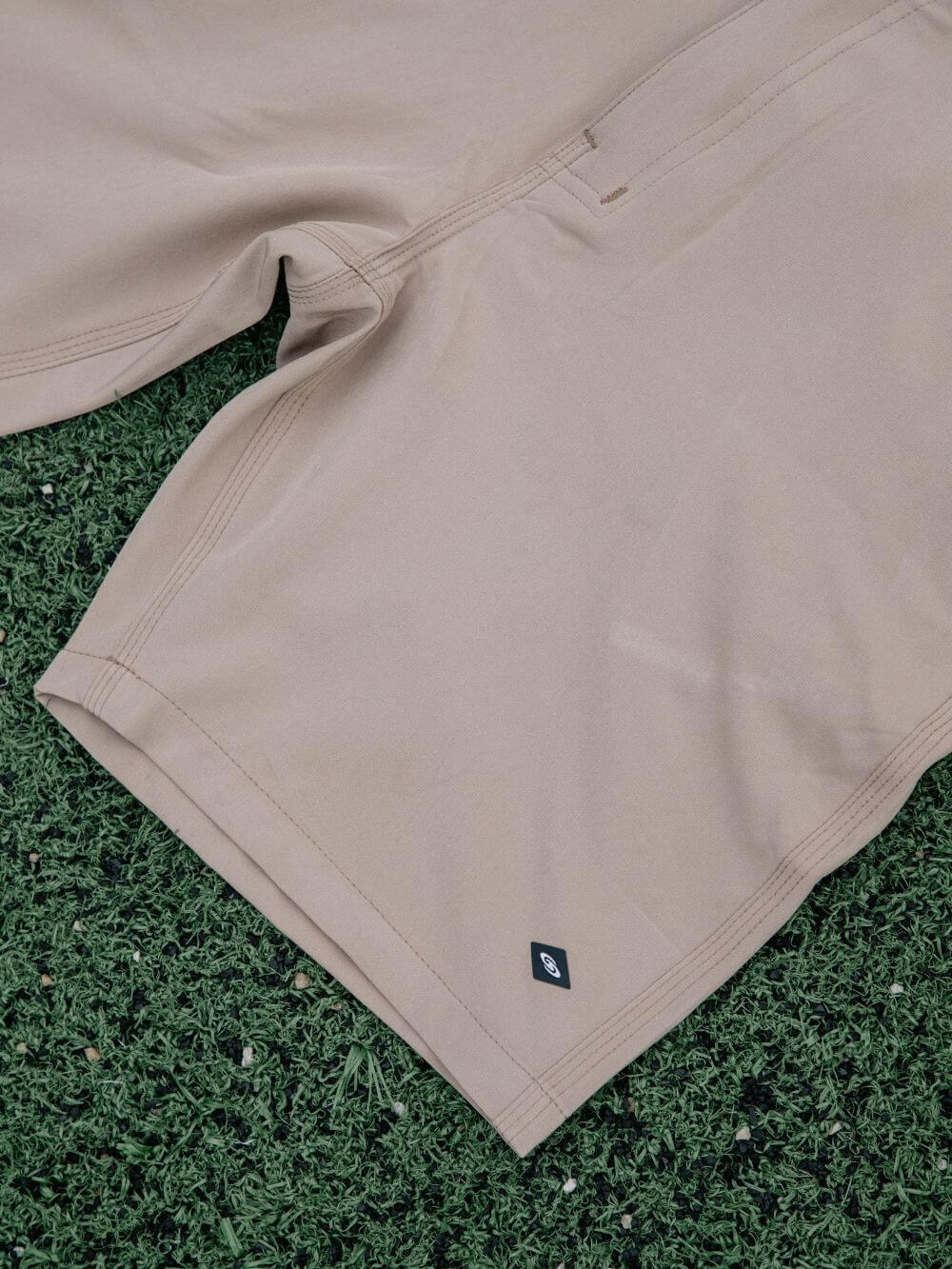 Bermuda Walkshort Classic Caqui da marca Greenish com botão e bolsos traseiros sobre fundo verde.