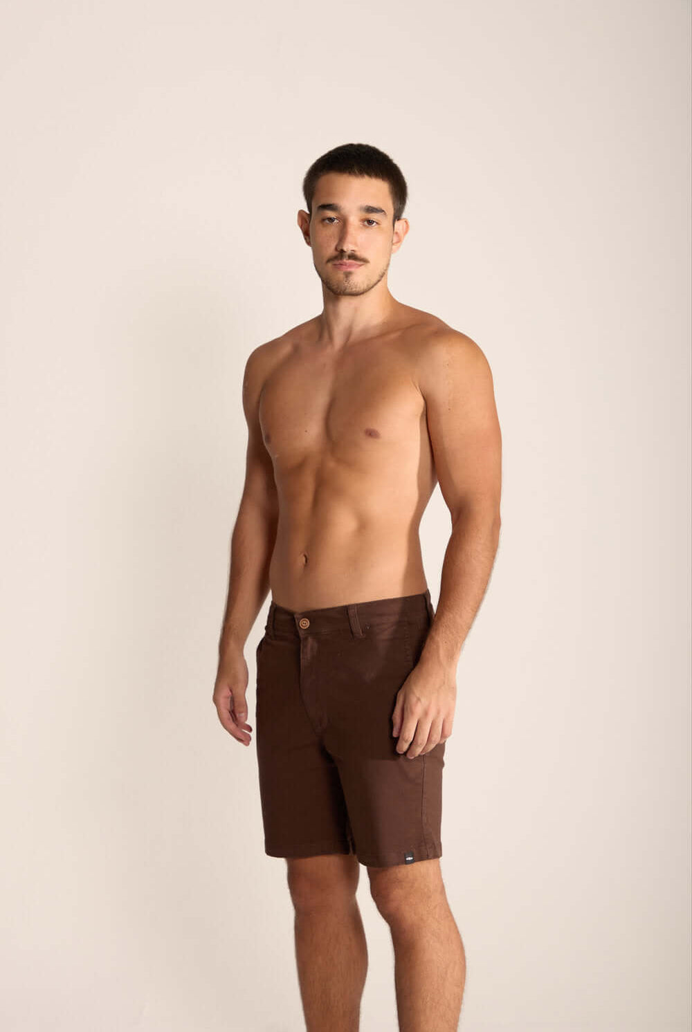 Modelo usando Bermuda Urban Marron, fino sarja premium, ideal para estilo de vida urbano e ao ar livre.