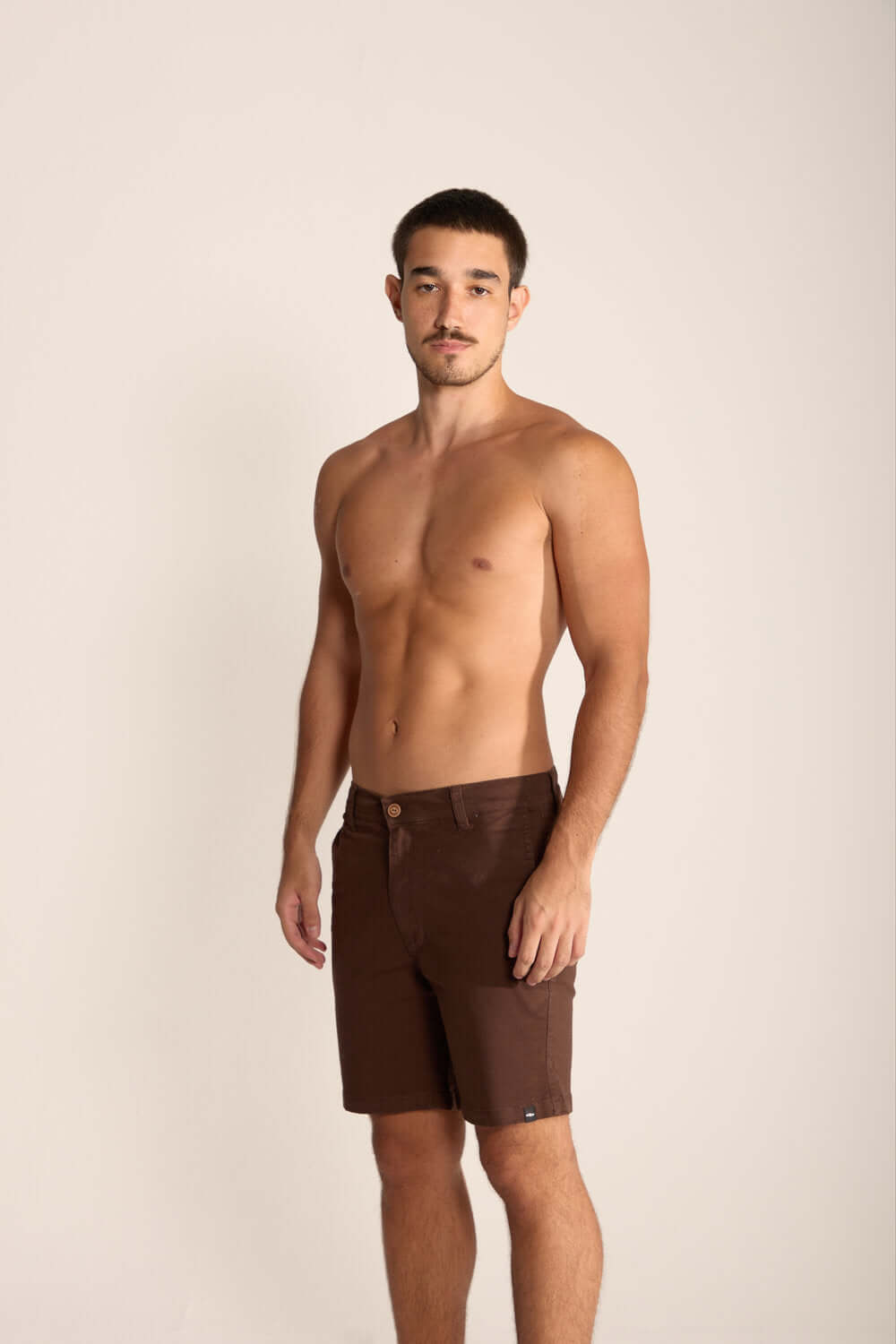 Modelo usando Bermuda Urban Marron, fino sarja premium, ideal para estilo de vida urbano e ao ar livre.