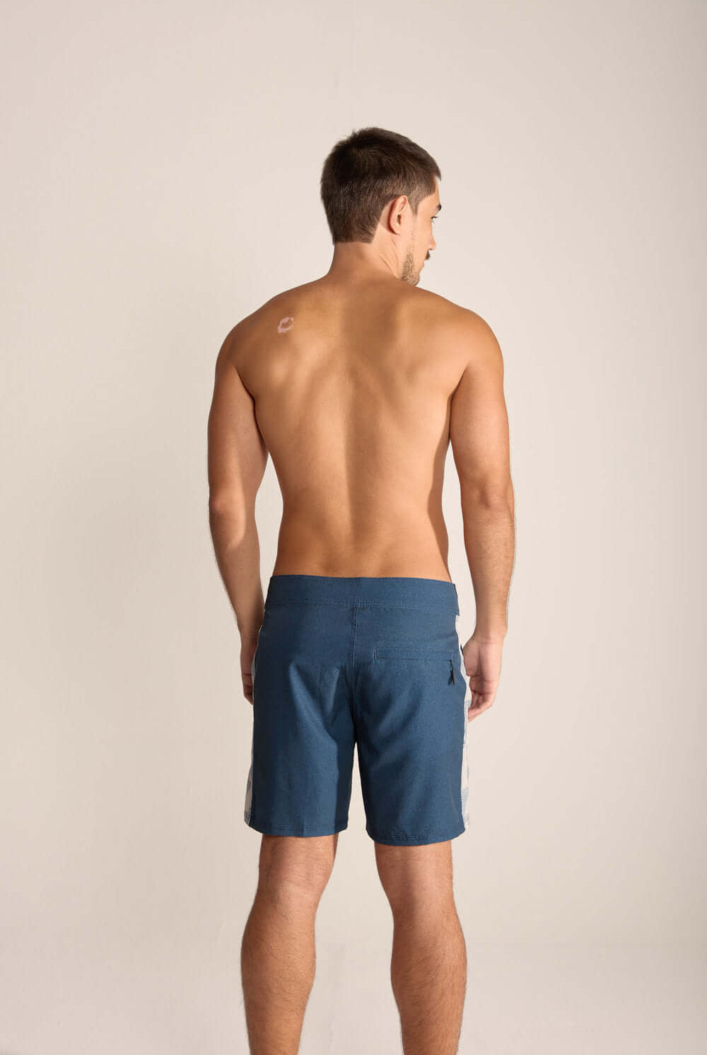 Back view of a man wearing Boardwalk Live the Simple swim shorts in Azul Marinho, showcasing lightweight design and style.