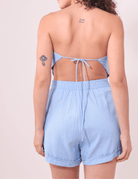 Mulher vestindo Blusa Lenço Luana Azul de costas, com detalhe de amarração nas costas. Marca Greenish. Moda feminina sofisticada e leve.