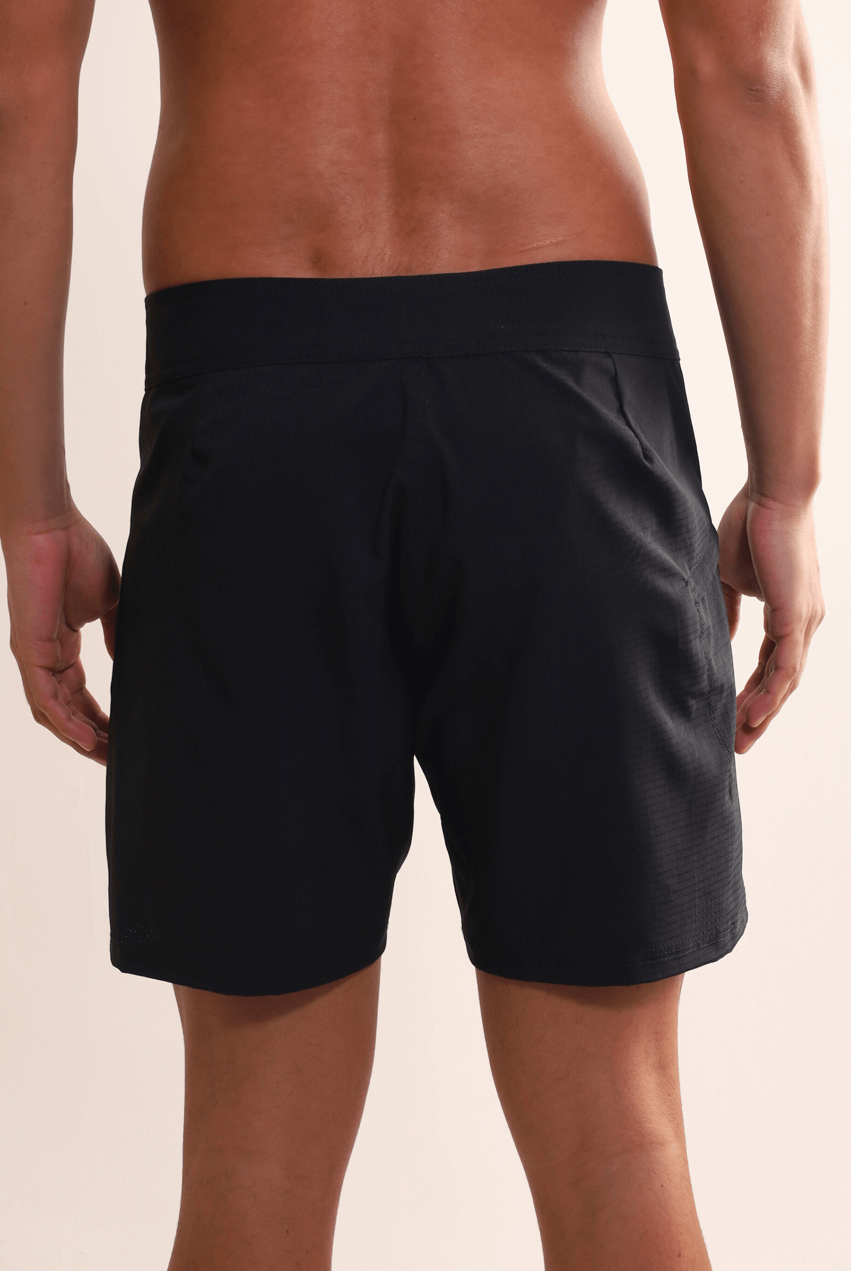 Homem vestindo Boardshort Sunset Preto da Greenish, destacando conforto e alta performance para atividades aquáticas, com secagem rápida.