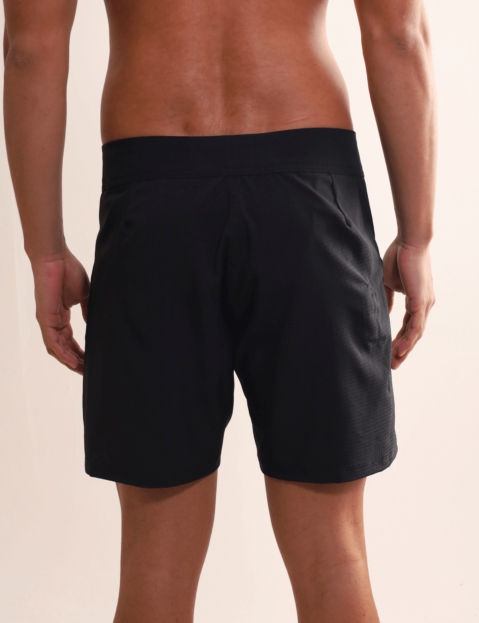 Homem vestindo Boardshort Sunset Preto da Greenish, destacando conforto e alta performance para atividades aquáticas, com secagem rápida.