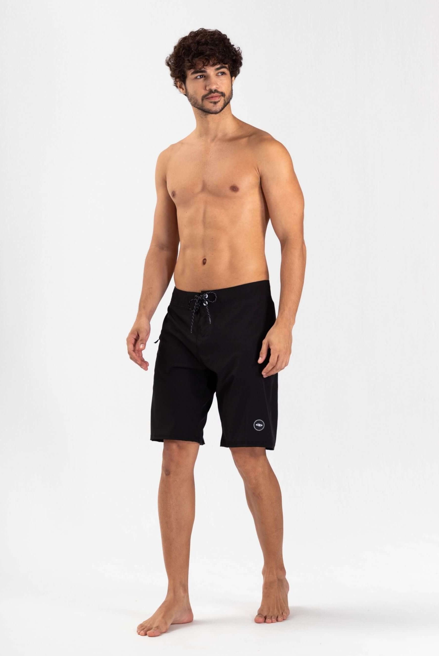 Modelo masculino usando boardshort Total Stretch Preto da Greenish, ideal para surf e aventuras aquáticas.