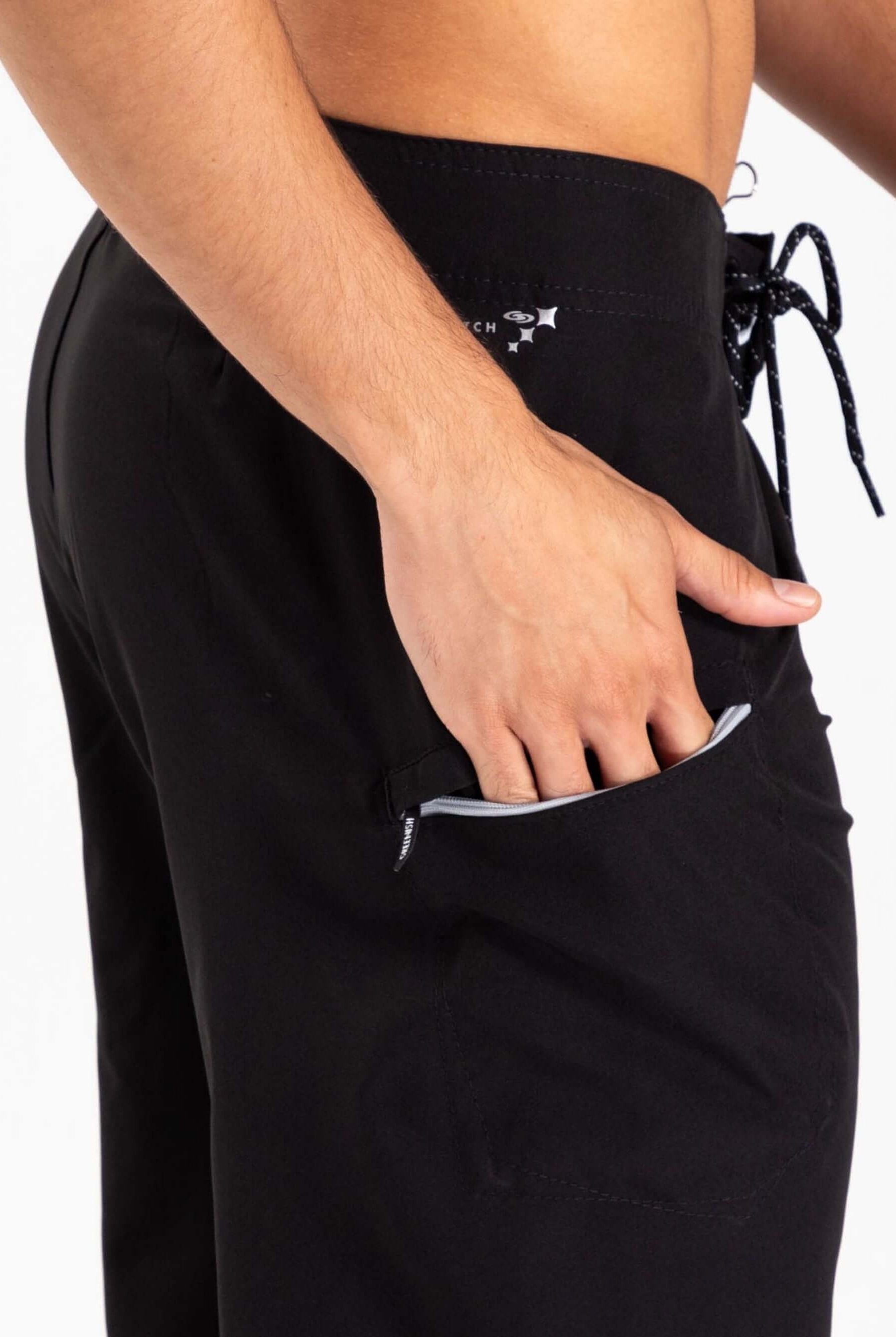 Modelo usando boardshorts Total Stretch Preto da Greenish, destacando bolso lateral e ajuste confortável.