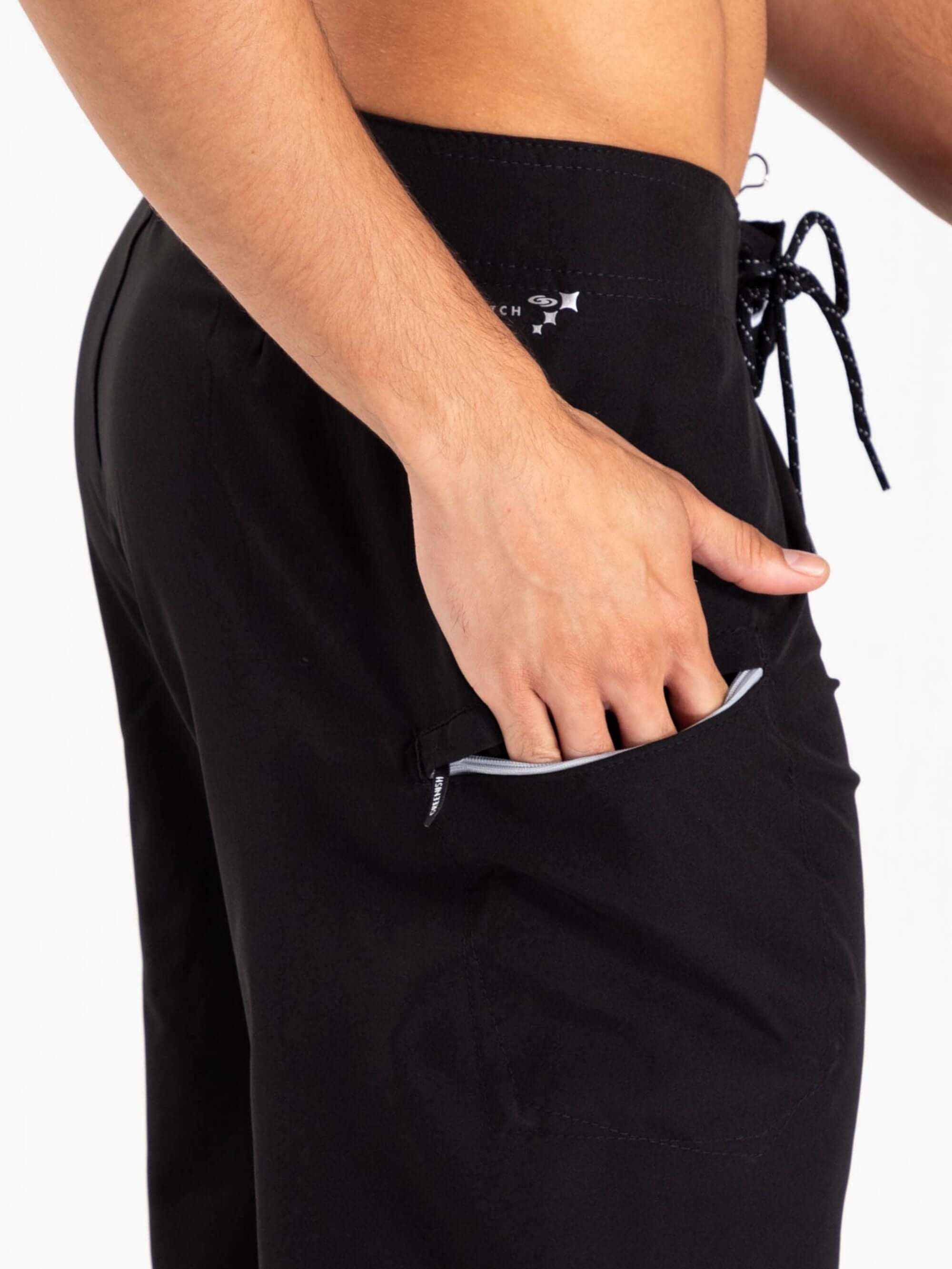 Modelo usando boardshorts Total Stretch Preto da Greenish, destacando bolso lateral e ajuste confortável.