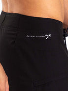 Detail of Greenish Total Stretch Boardsport shorts showcasing logo and side pocket for enhanced performance.