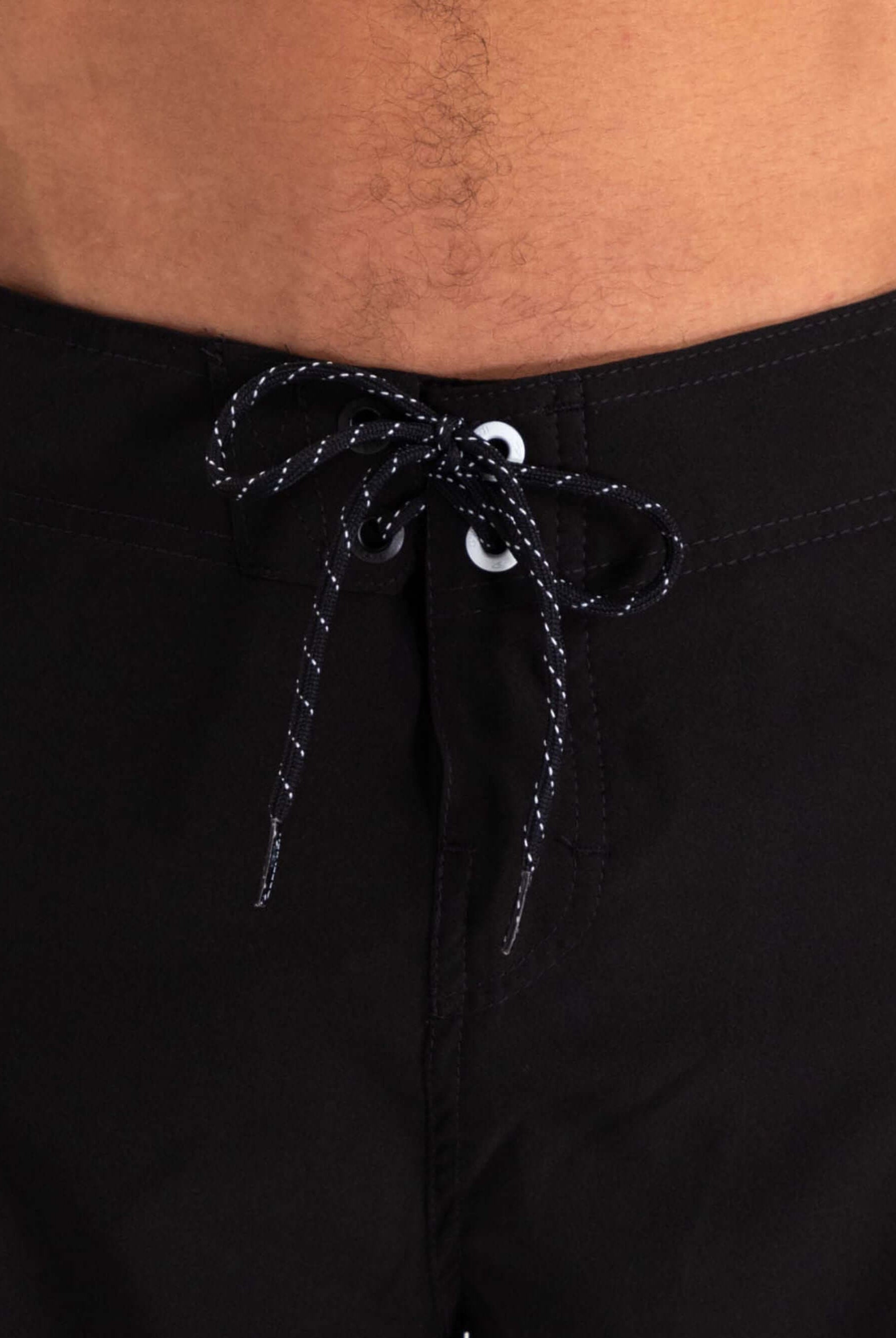 Close-up of Greenish Ultralight Basic boardshort in black, showcasing waist drawstring and stretch fabric for comfort.