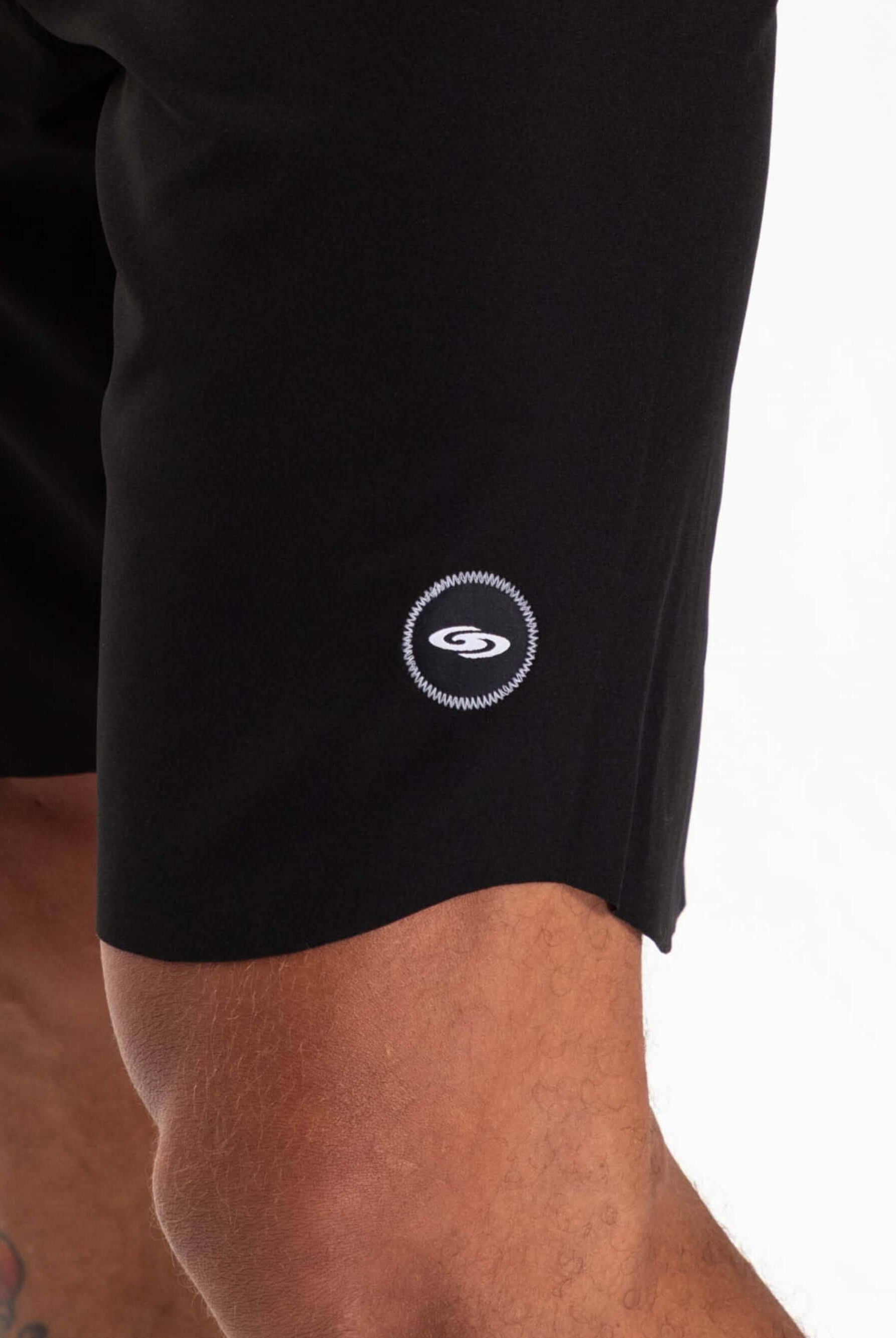 Close-up of the Greenish Ultralight Basic boardshort in black, showcasing the brand logo and premium fabric details.