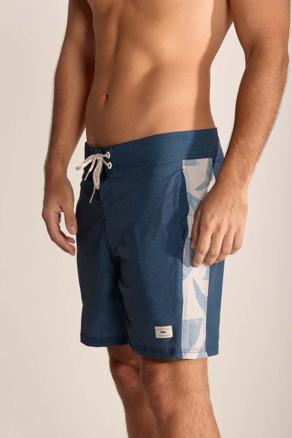 Homem usando shorts de banho azul marinho com estampa, ideal para praia e atividades ao ar livre.