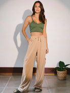 Modelo usando top verde e calças largas em ambiente iluminado, representando conforto e estilo da marca Greenish.