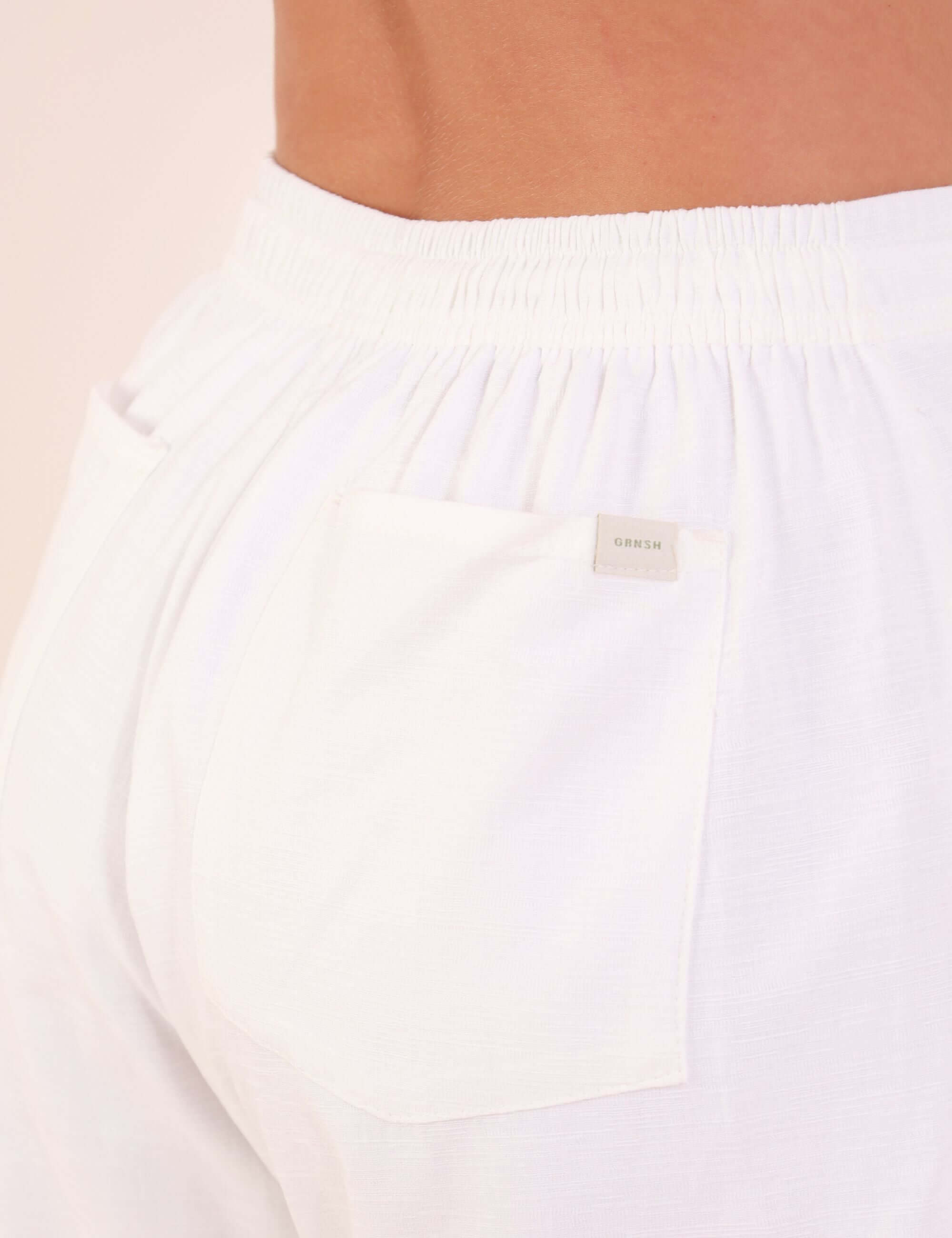 Detalhe tecido e bolso da Calça Reta Milena - Off White em algodão e viscose, destacando o acabamento sofisticado e cós elástico.
