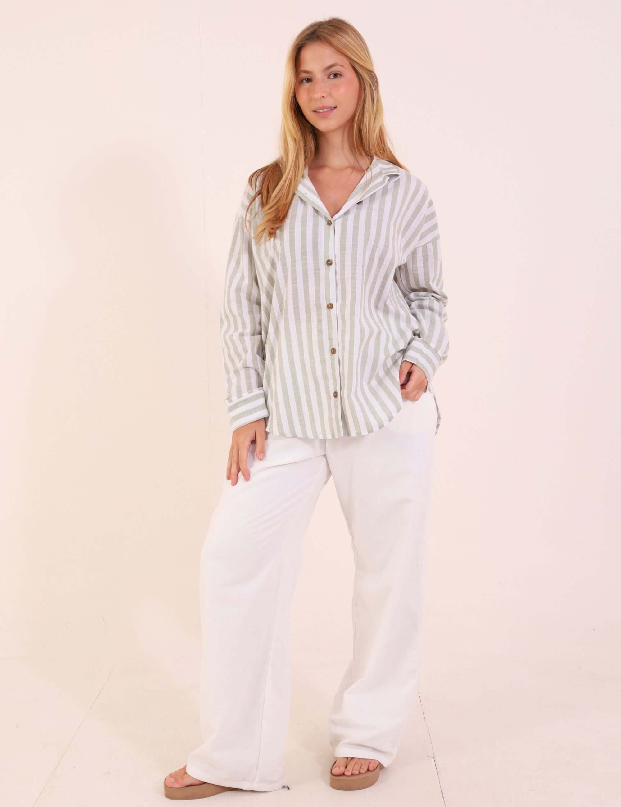 Mulher usando Camisa Marine - Verde de algodão com listras, modelagem ampla e punhos estruturados, ideal para looks casuais ao ar livre.