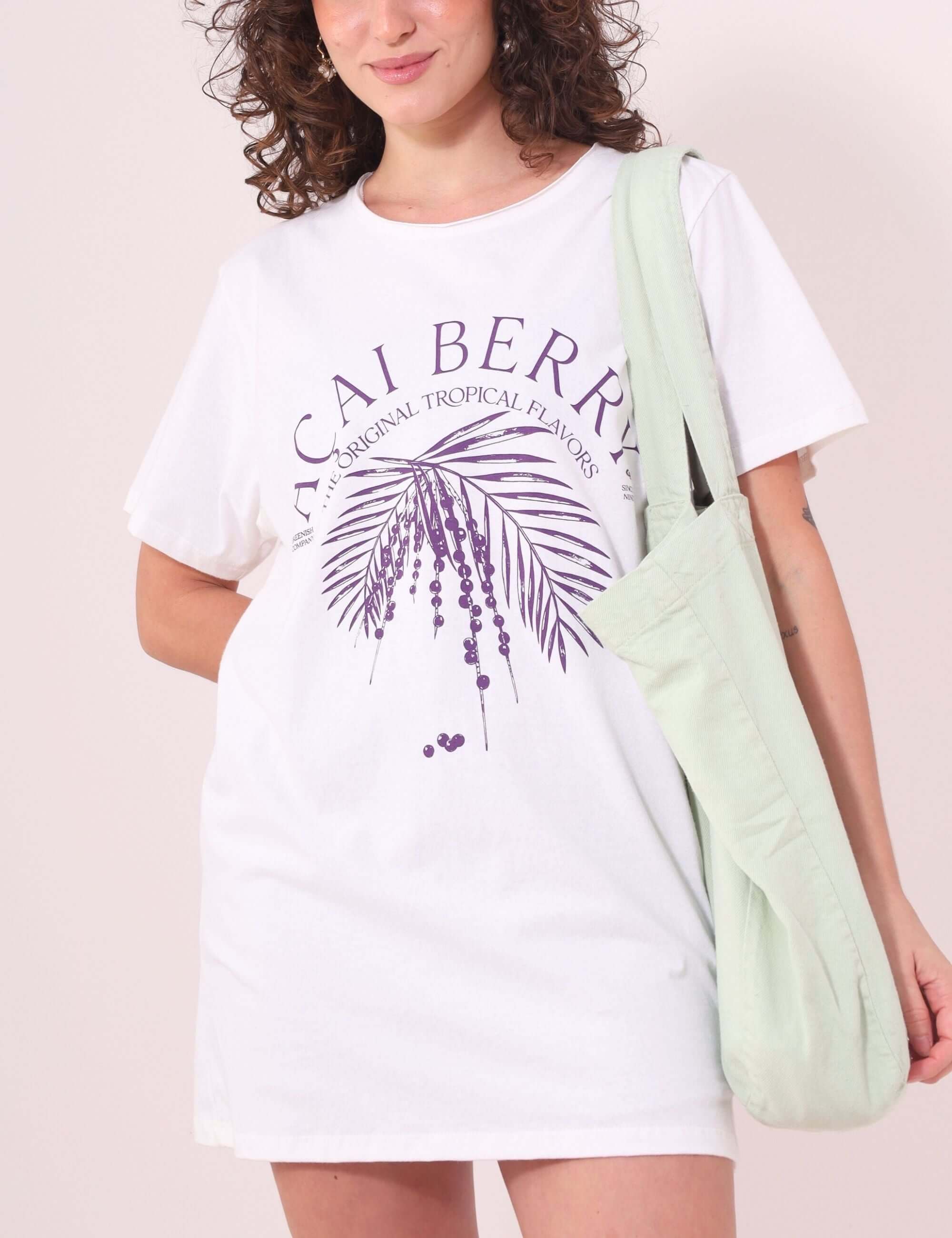 Mulher vestindo Camiseta Açaí Berry da Greenish, off-white em algodão, modelagem ampla despojada. Ideal para looks descontraídos e leves.