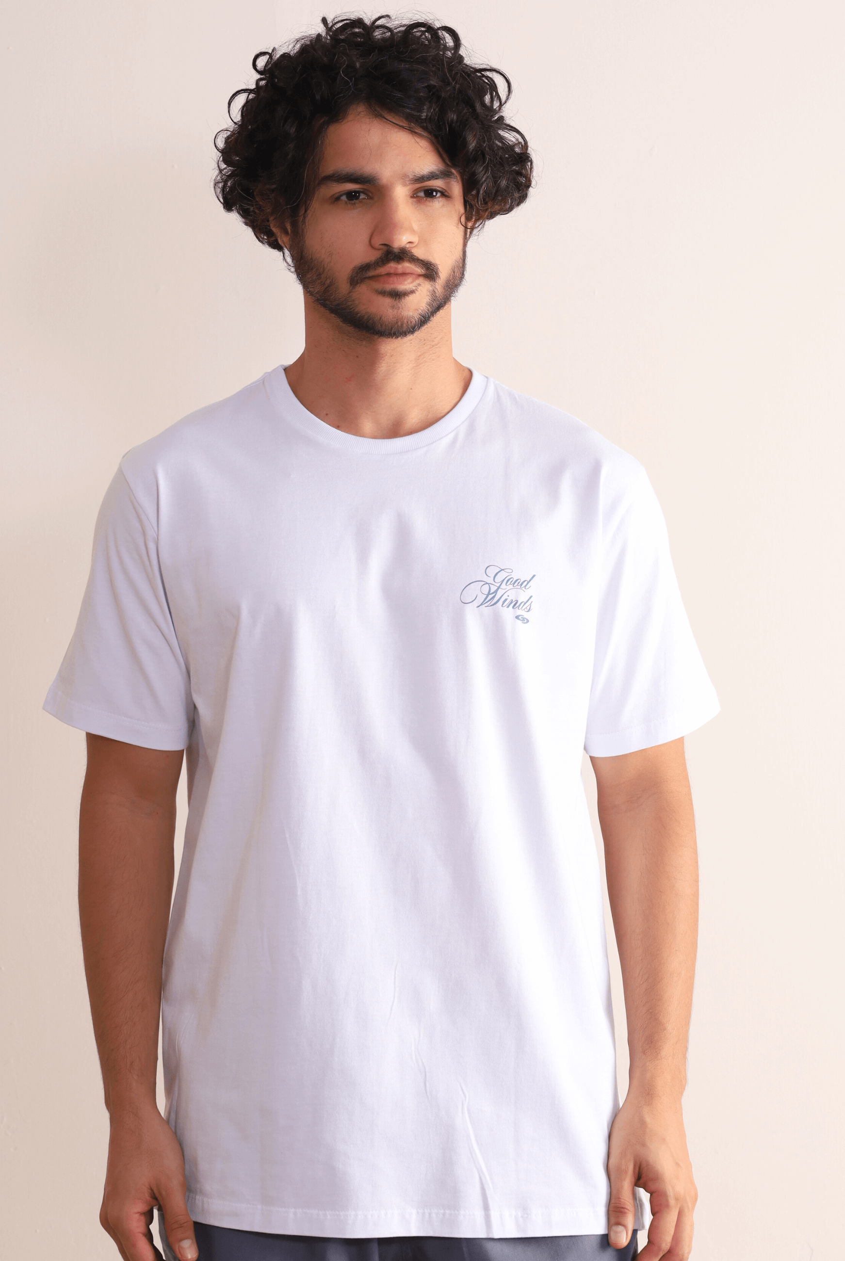 Homem vestindo camiseta branca Kites & Good Winds da marca Greenish, com bordado frontal, modelagem clássica e toque macio em algodão.