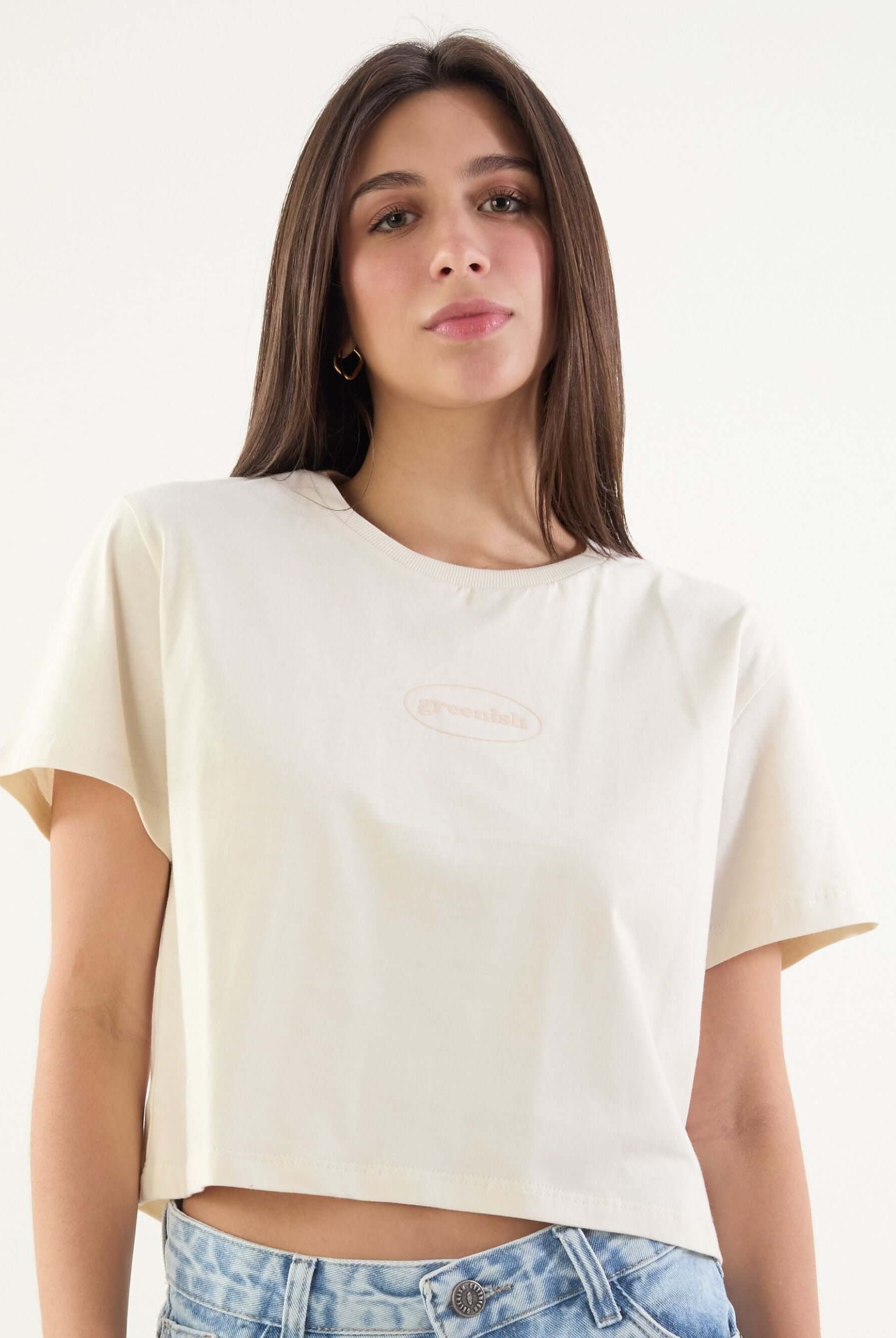 Camiseta cropped bege da marca Greenish, com manga curta e estilo moderno, ideal para lookscasuais.