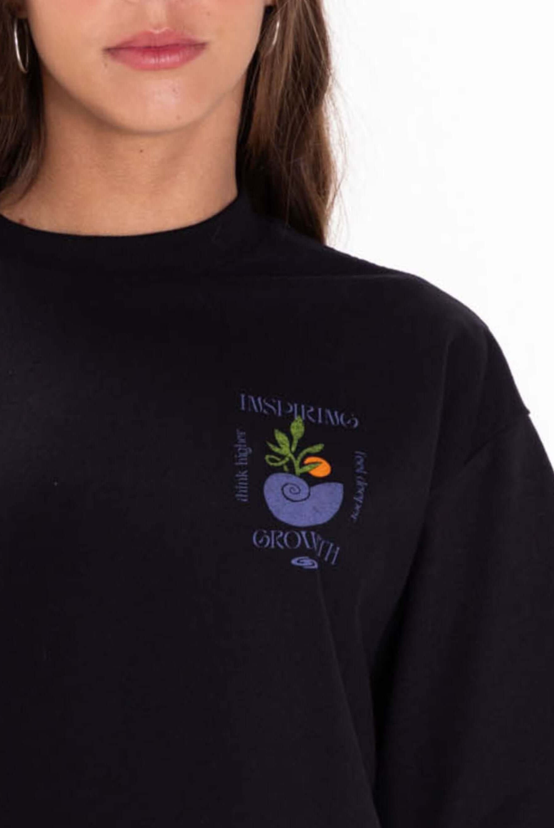 Camiseta cropped preta da marca Greenish com estampa "Inspiring Growth" em destaque.