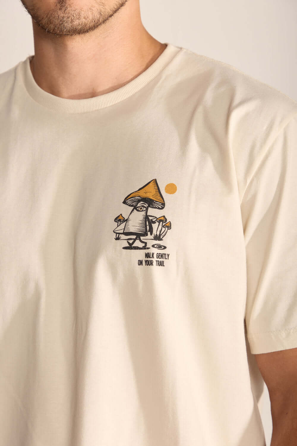 Camiseta Gentle Mushroom bege com estampa divertida de cogumelo e mensagem "walk gently on your trail".