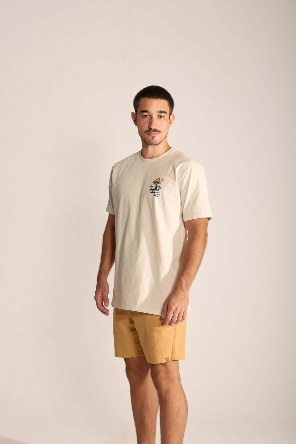 Model wearing Gentle Mushroom beige t-shirt, showcasing playful mushroom design and relaxed fit, perfect for nature lovers.
