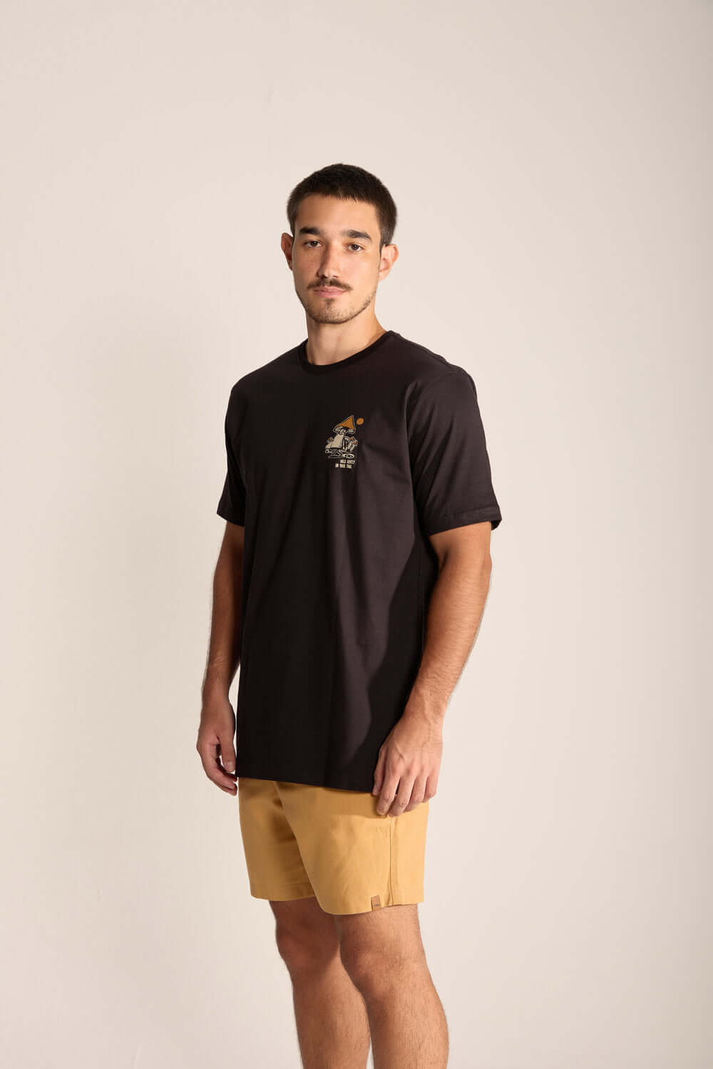 Man wearing a black Gentle Mushroom t-shirt with stylish design, showcasing a connection with nature and conscious lifestyle.
