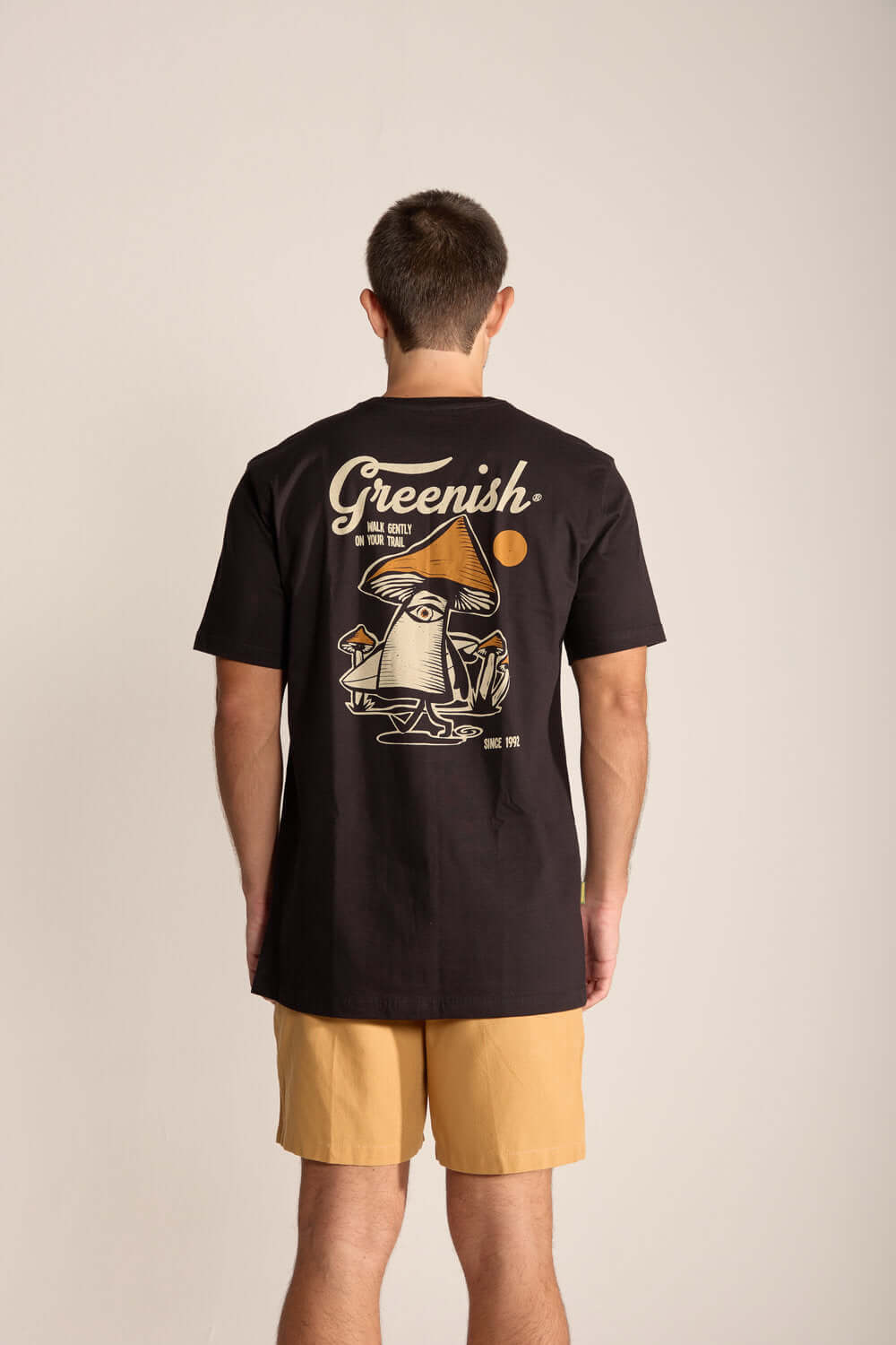 Camiseta Gentle Mushroom preta com estampa divertida de cogumelo nas costas, promovendo um lifestyle leve e consciente.