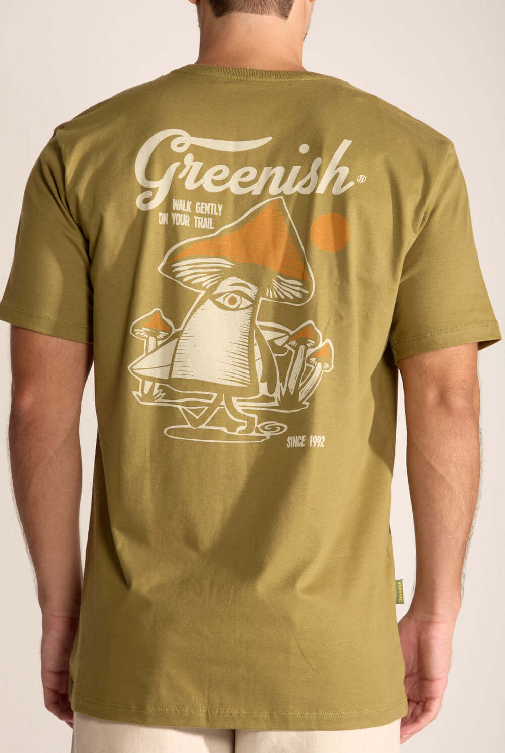 Camiseta Gentle Mushroom Verde Oliva com estampa divertida de cogumelo nas costas, simbolizando conexão com a natureza.