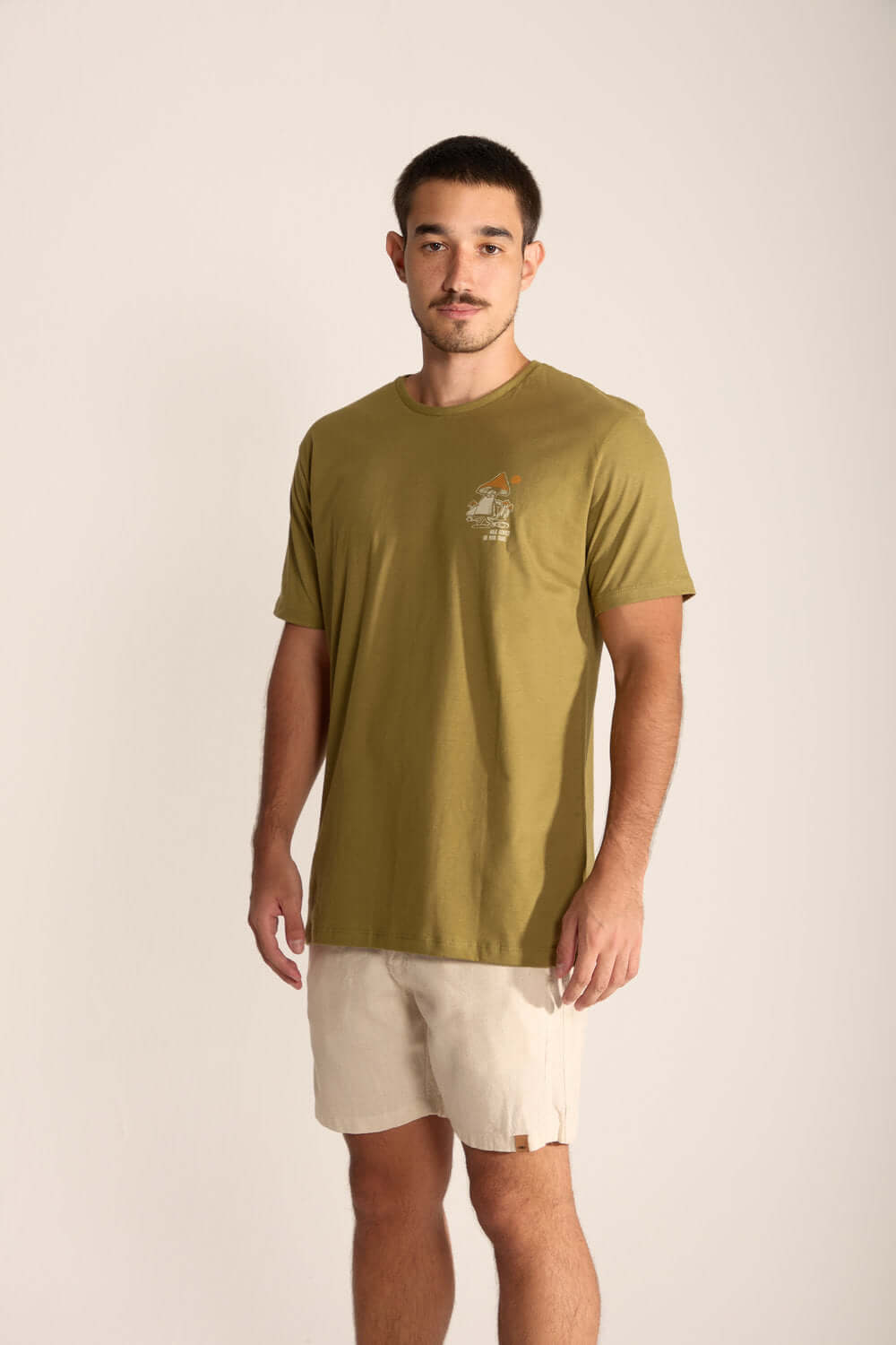 Model wearing Gentle Mushroom t-shirt in olive green, featuring a stylized mushroom design.