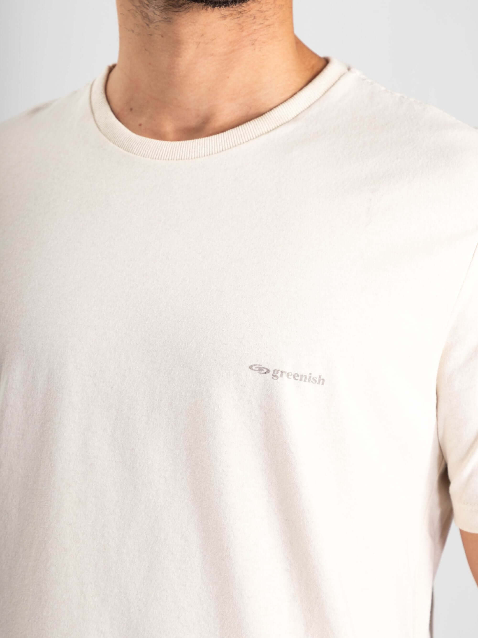 Camiseta Greenish Classic off white com logo em destaque, feita de algodão 100% e malha soft touch.