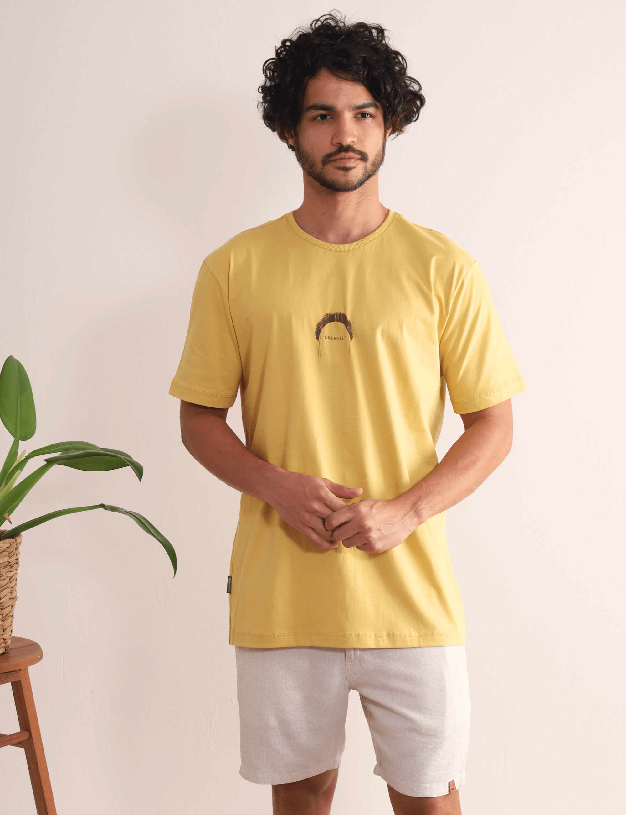 Homem vestido com a Camiseta Fund Out New Places Amarelo Escuro da Greenish, inspirada no kite, ideal para aventuras ao ar livre.