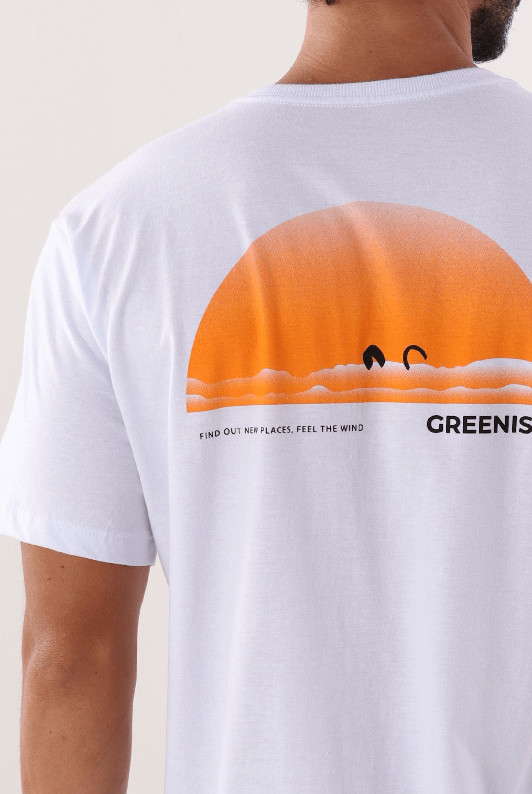 Camiseta branca 'Find Out New Places' da marca Greenish, apresentando design de pôr do sol laranja na parte traseira.