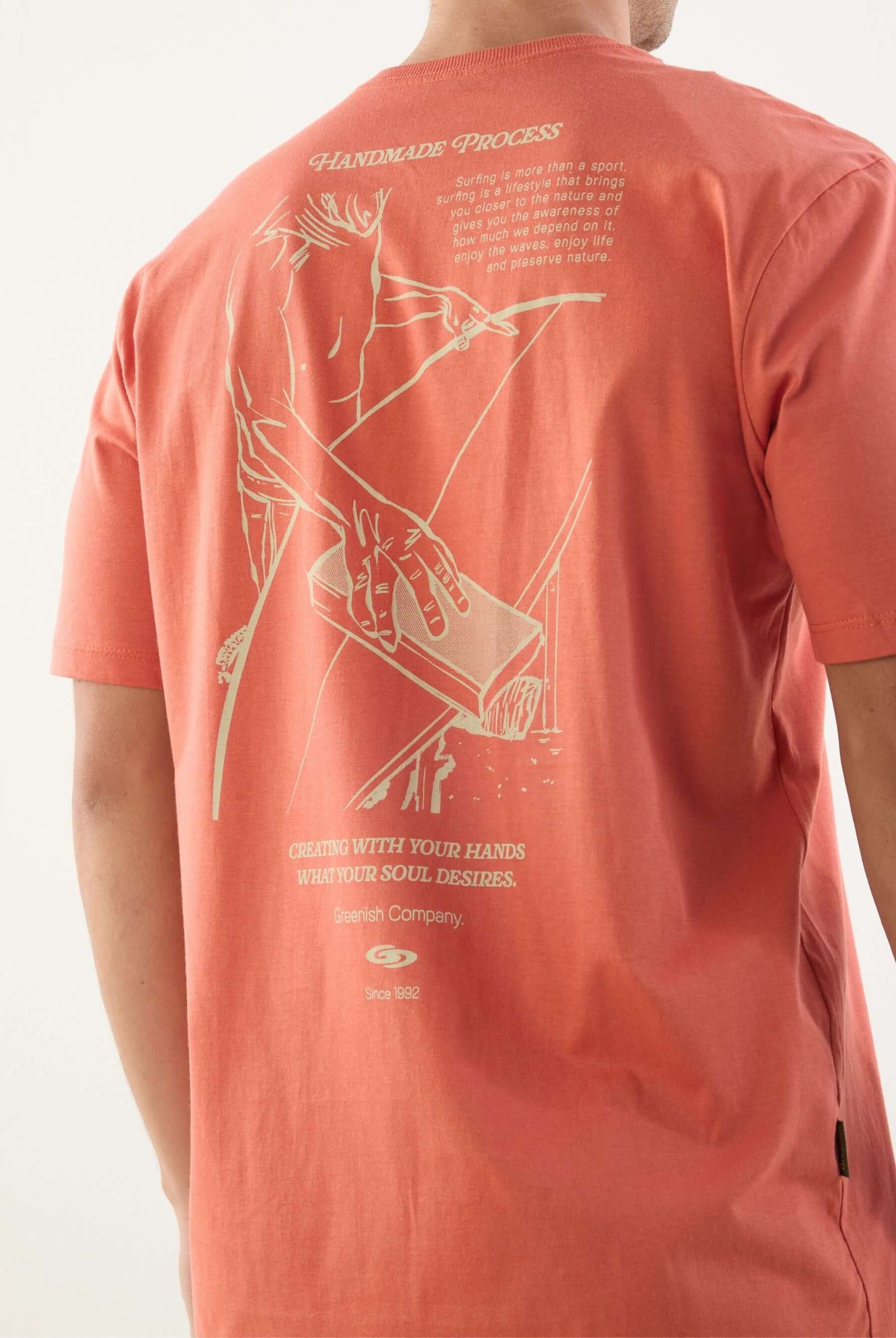 Camiseta Handmade Process da Greenish, cor salmão, com estampa exclusiva nas costas, ideal para amantes do surf.