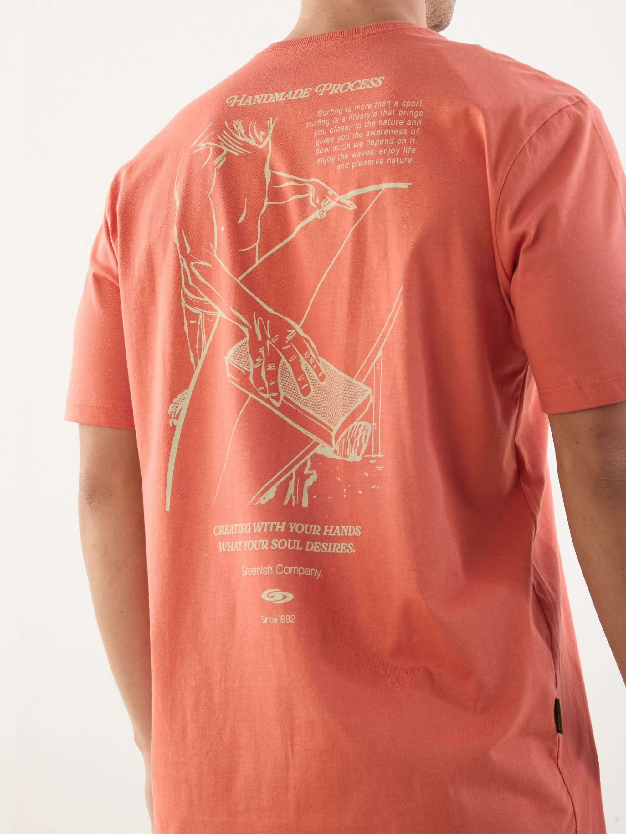 Camiseta Handmade Process da Greenish, cor salmão, com estampa exclusiva nas costas, ideal para amantes do surf.