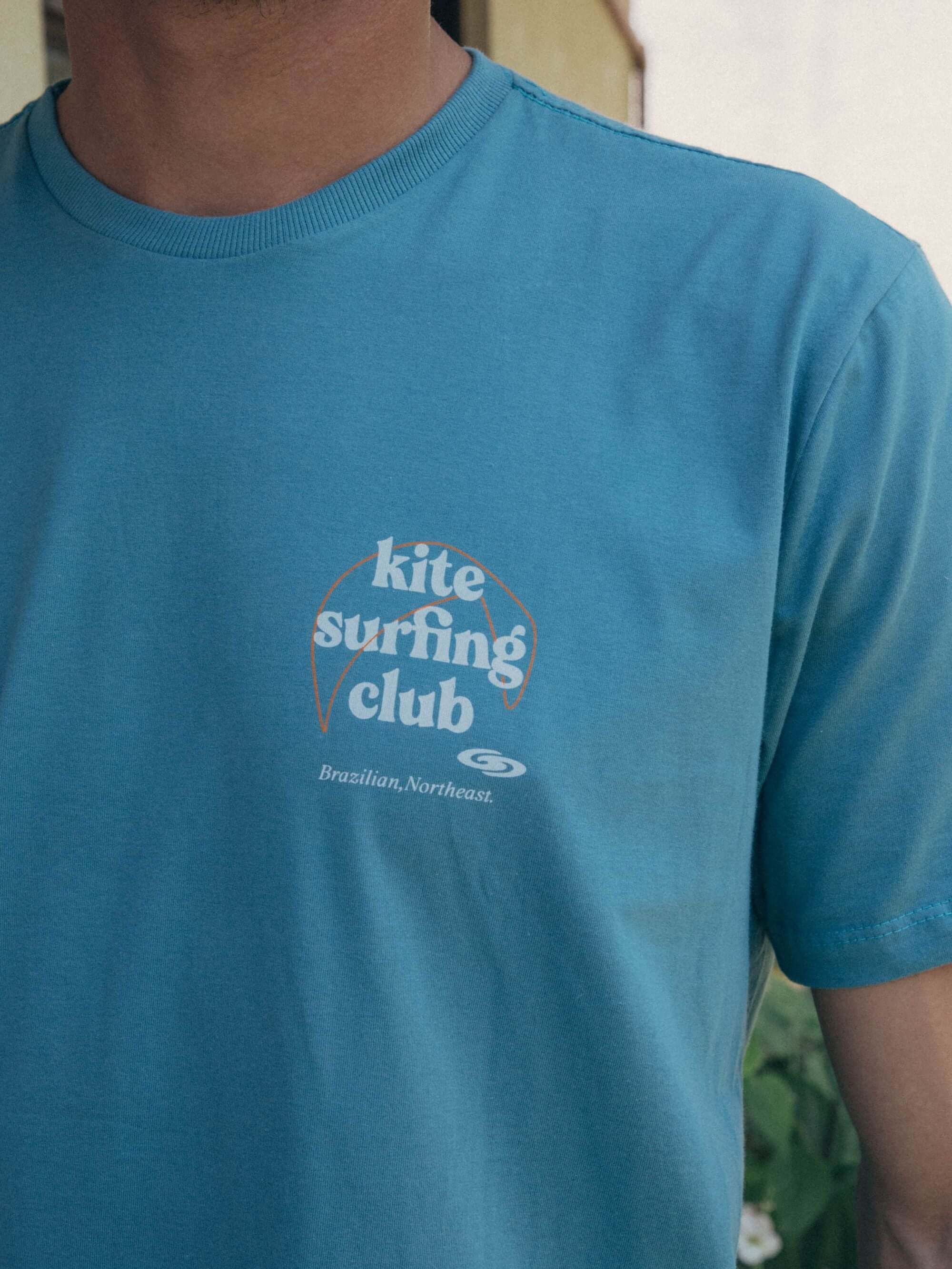 Camiseta azul meio com estampa do Kite Surfing Club, perfeita para amantes de esportes aquáticos. Conforto e estilo Greenish.