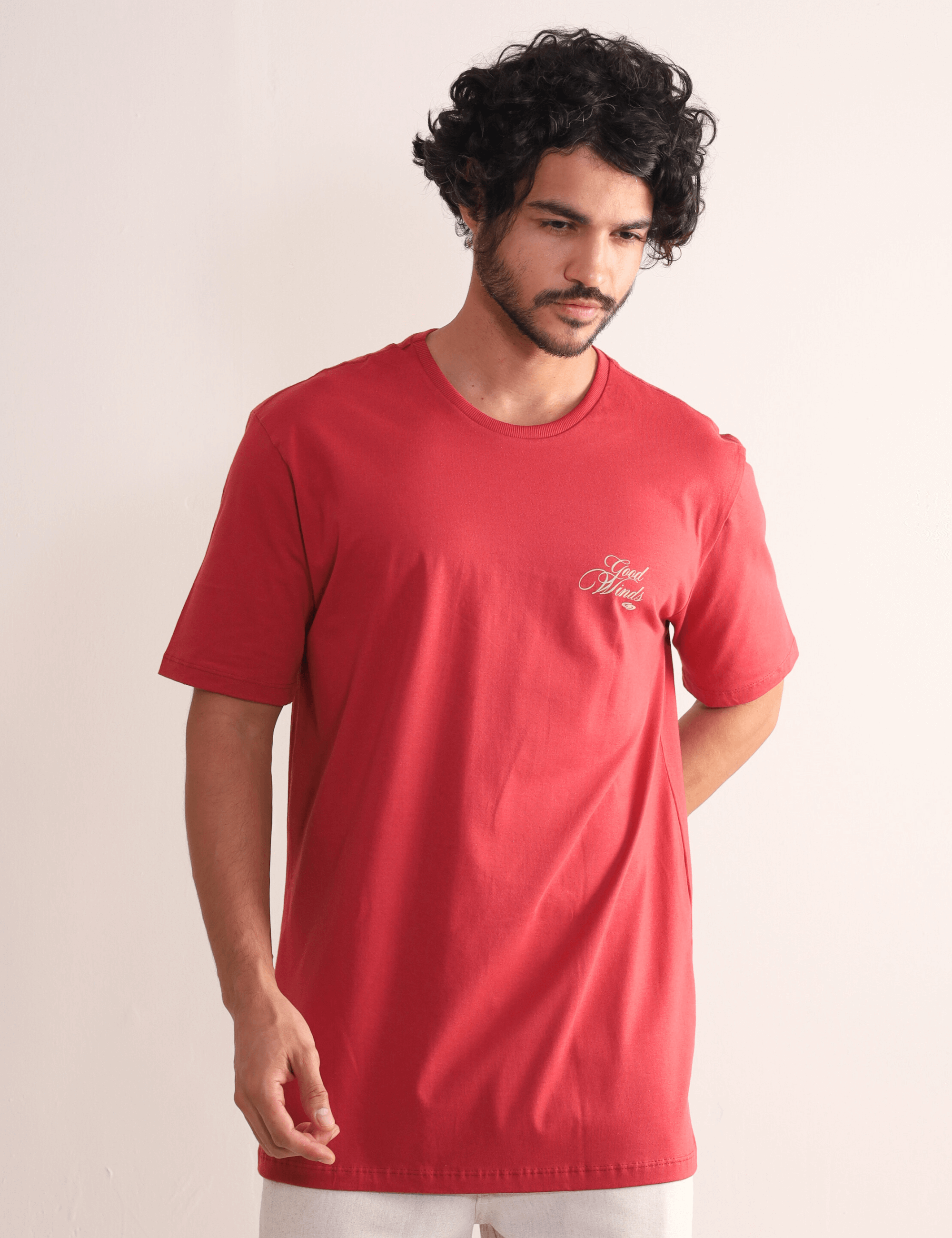 Homem vestindo Camiseta Kites & Good Winds Vermelho da Greenish, modelo clássico em algodão com bordado frontal, ideal para conforto e estilo.