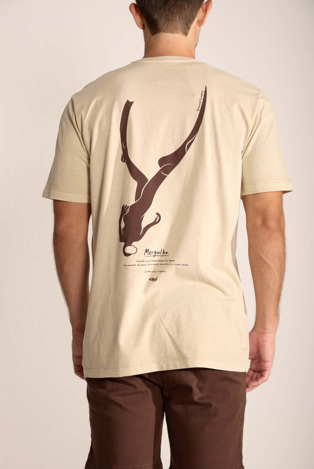 Camiseta Mergulhador da Greenish em cor areia, com estampa artística nas costas e modelagem clássica.