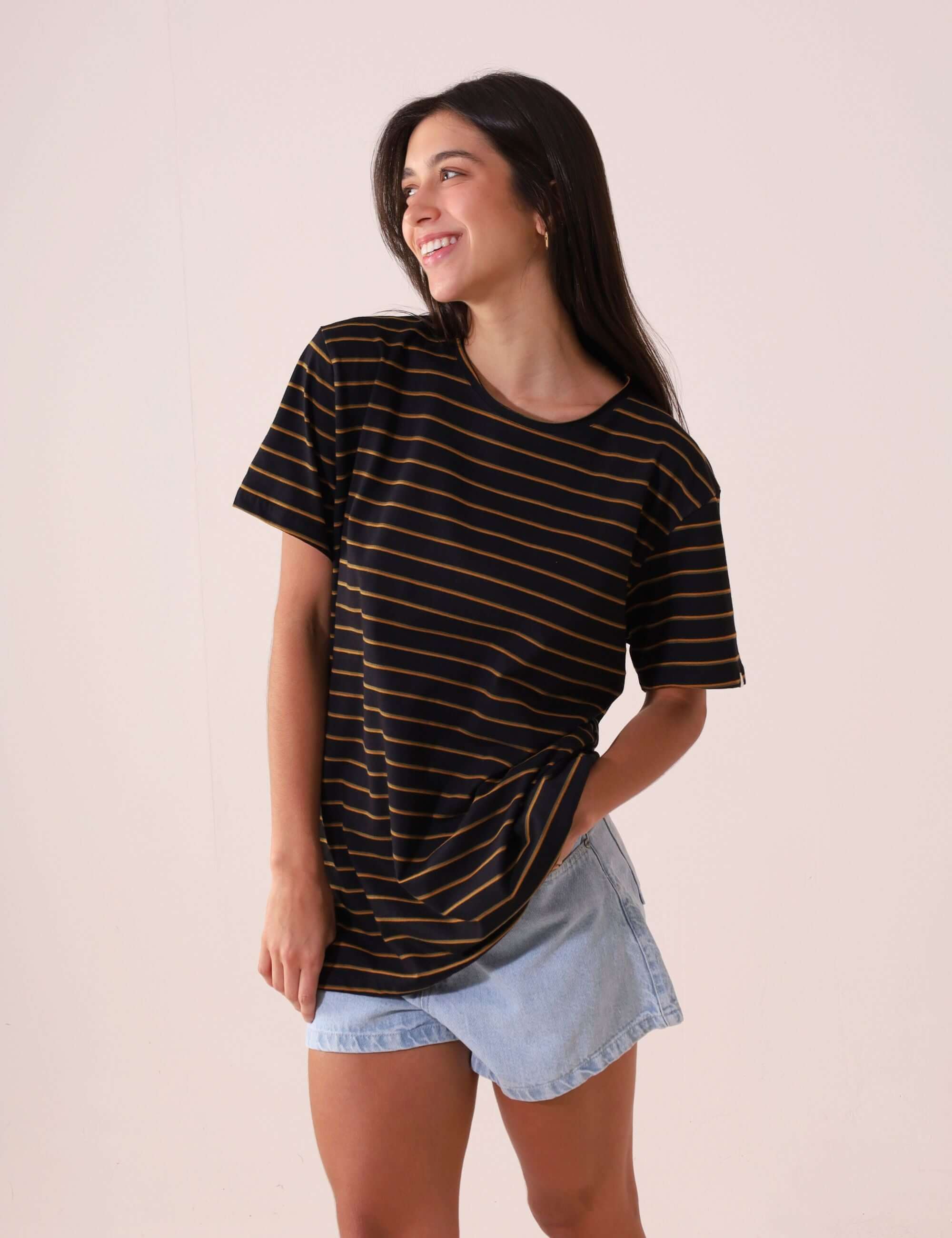 Mulher vestindo CAMISETA NAUTIC - PRETO da Greenish, maxi camiseta feminina com listras, confortável e estilo versátil, ideal para vida ao ar livre.