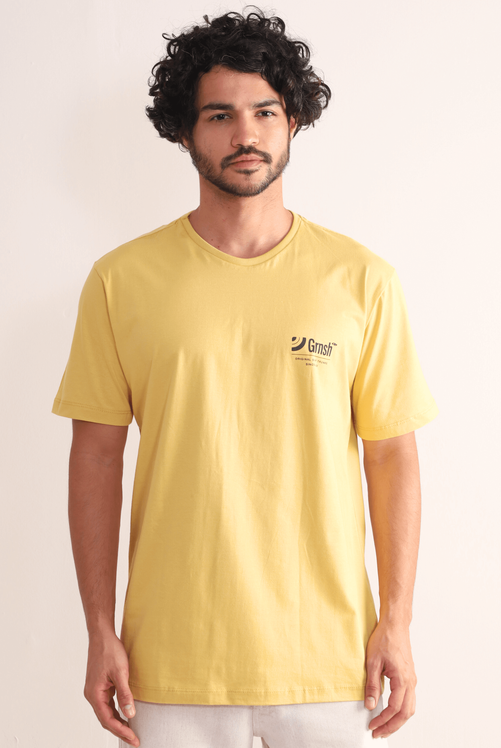 Camiseta Amarelo Escuro Greenish com estampa Surf Trunks, estilo litorâneo e conforto casual, ideal para qualquer ocasião.