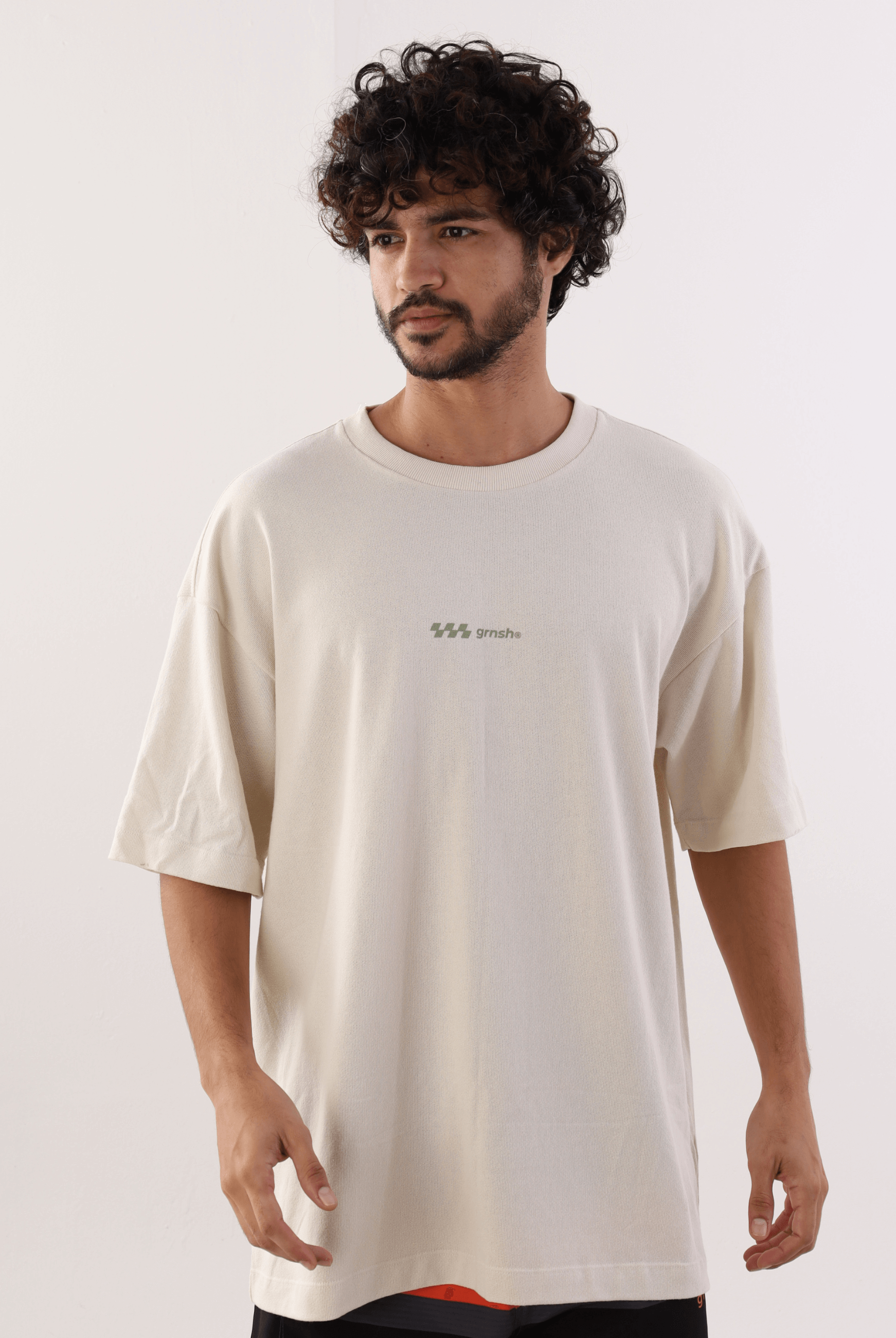 Homem vestindo Camiseta Oversized Hexagon Lines Bege da marca Greenish, com design de linhas hexagonais em algodão confortável.
