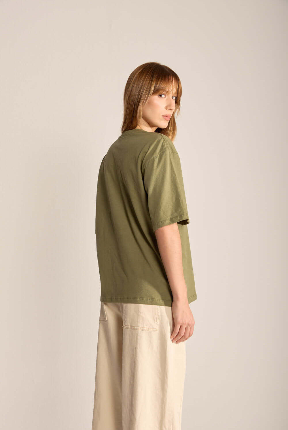 Camiseta Oversized Verde Walk Gently da Greenish, modelo feminino visto de costas com estilo descontraído.