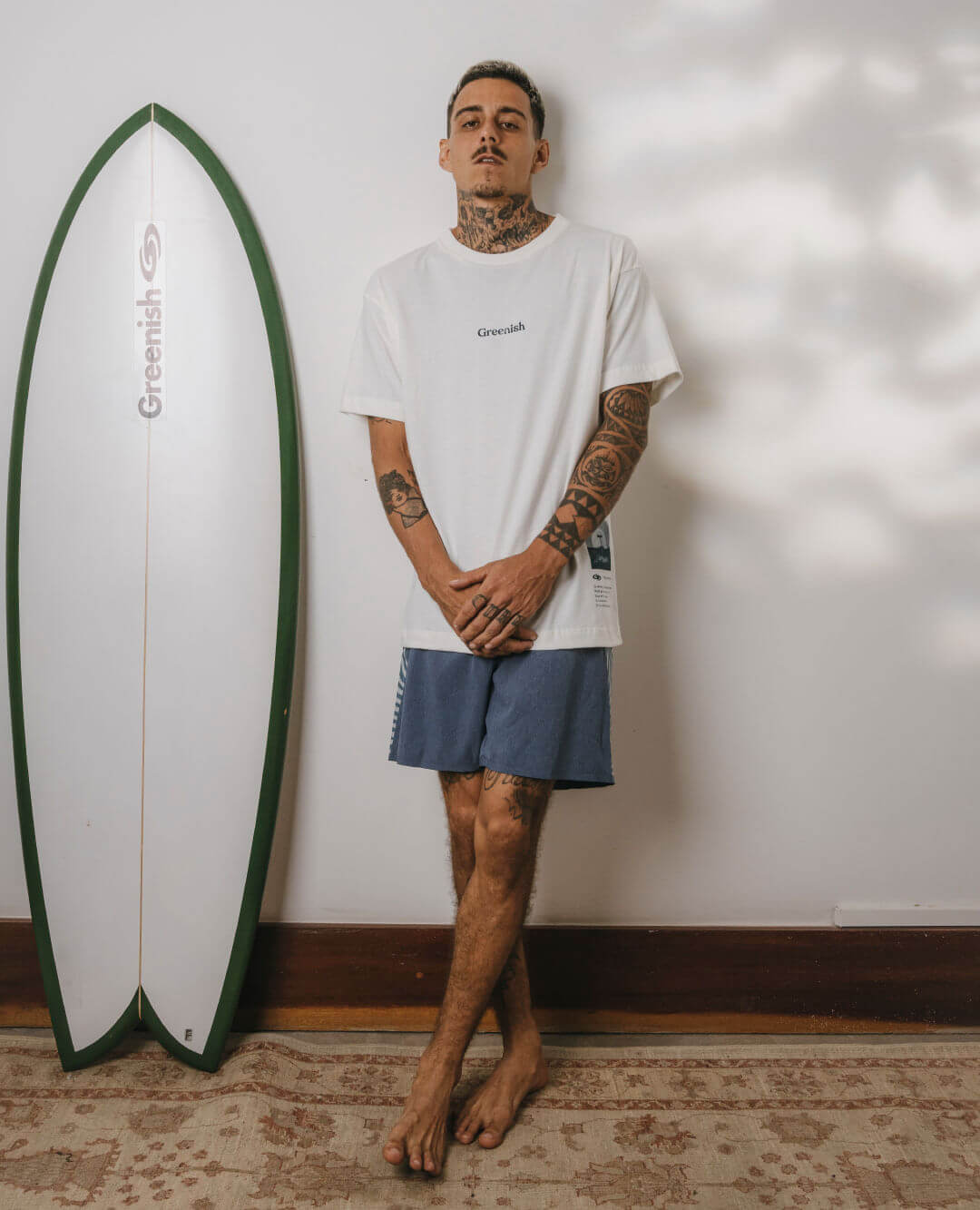 Camiseta oversized off white da marca Greenish, com modelo usando em ambiente descontraído.