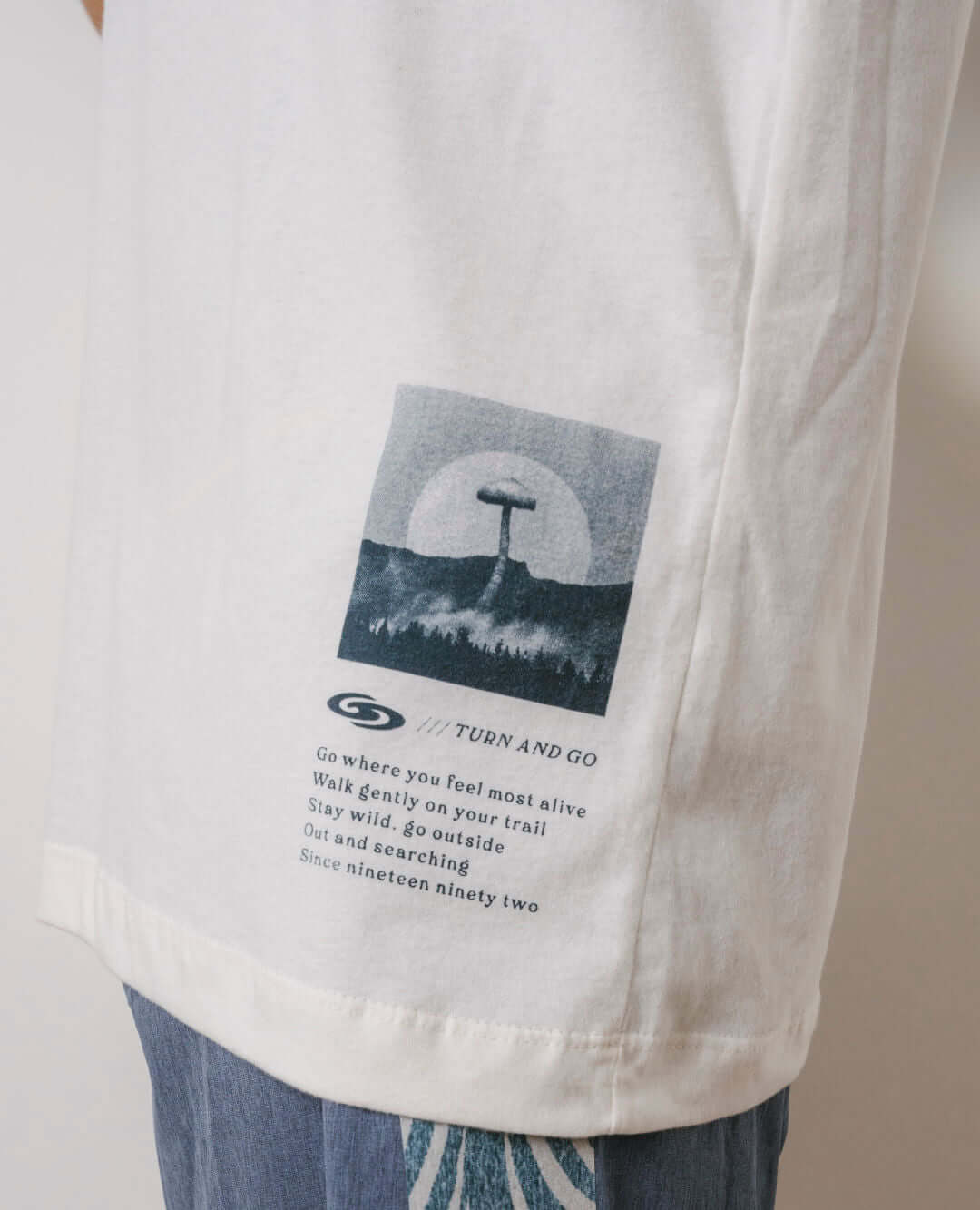 Camiseta oversized off white da Greenish com estampa de cogumelo e mensagem inspiradora na lateral.