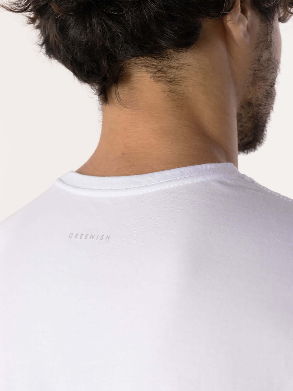 Detalhe da parte de trás da camiseta branca Pima Essential da Greenish, mostrando a etiqueta delicada.