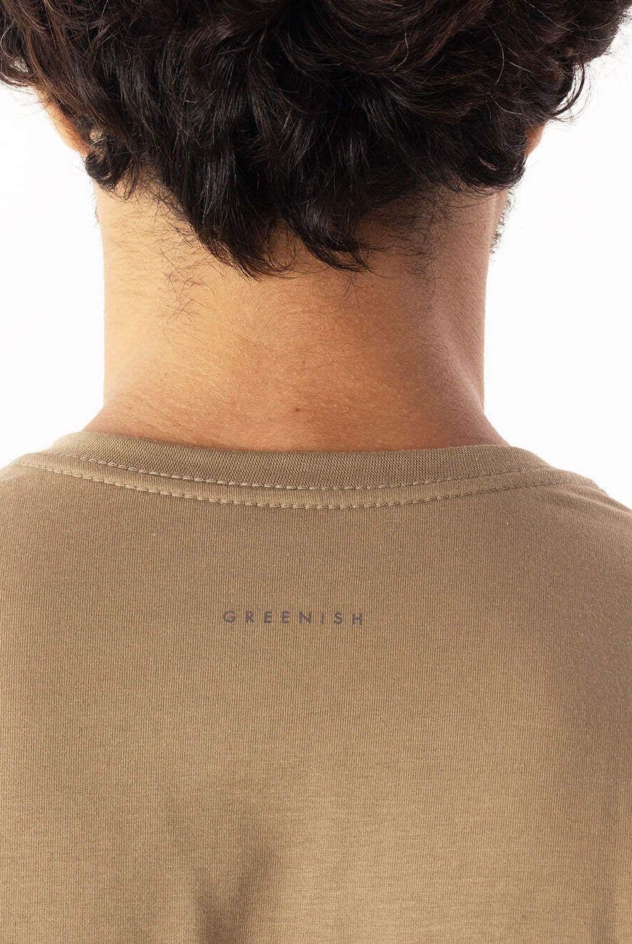 Detalhe da camiseta Pima Essential caqui da Greenish, mostrando o logo na parte de trás.