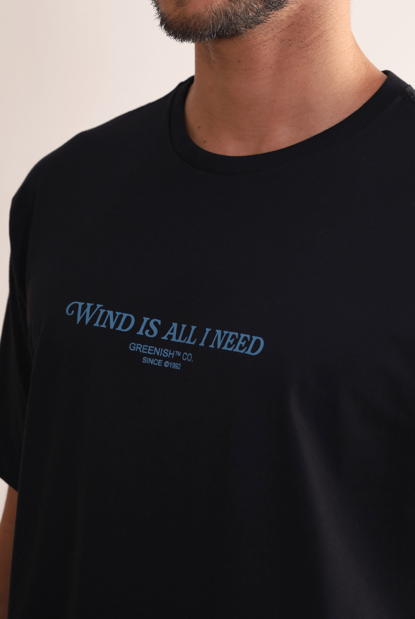 Camiseta preta "Wind Is All I Need" da Greenish, estampa frontal, confortável para movimentos livres.