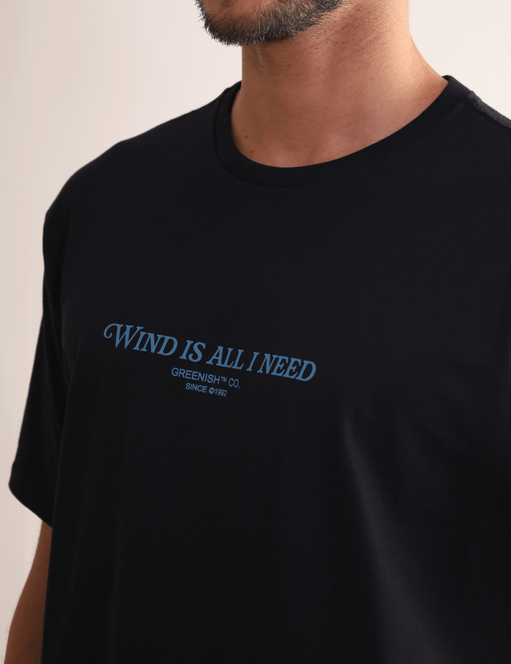 Camiseta preta "Wind Is All I Need" da Greenish, estampa frontal, confortável para movimentos livres.